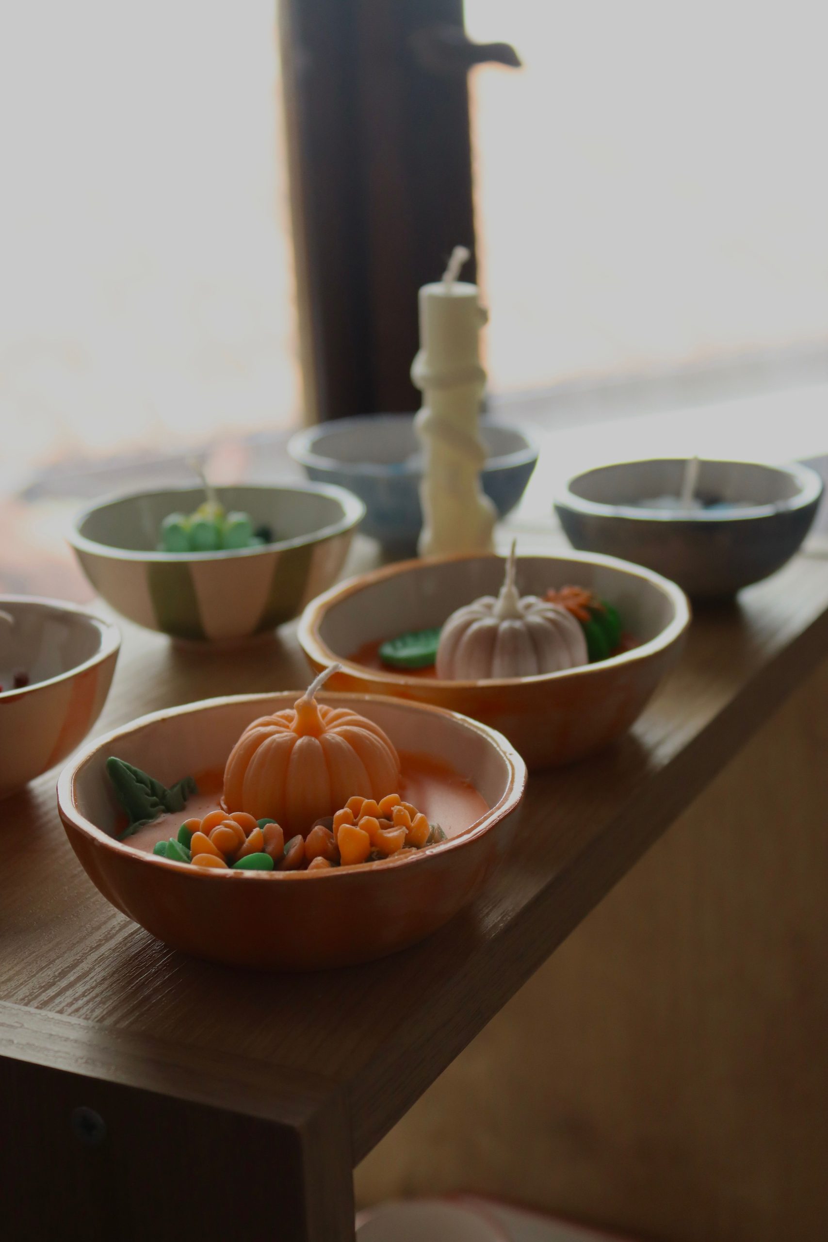 Charming tabletop display of decorative pumpkin candles, perfect for fall ambiance.
