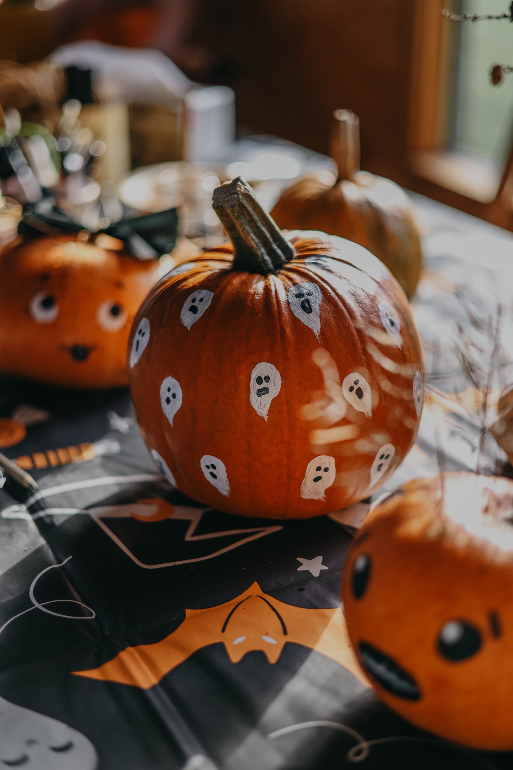 Close-up of painted pumpkins with ghost designs for Halloween decoration.
