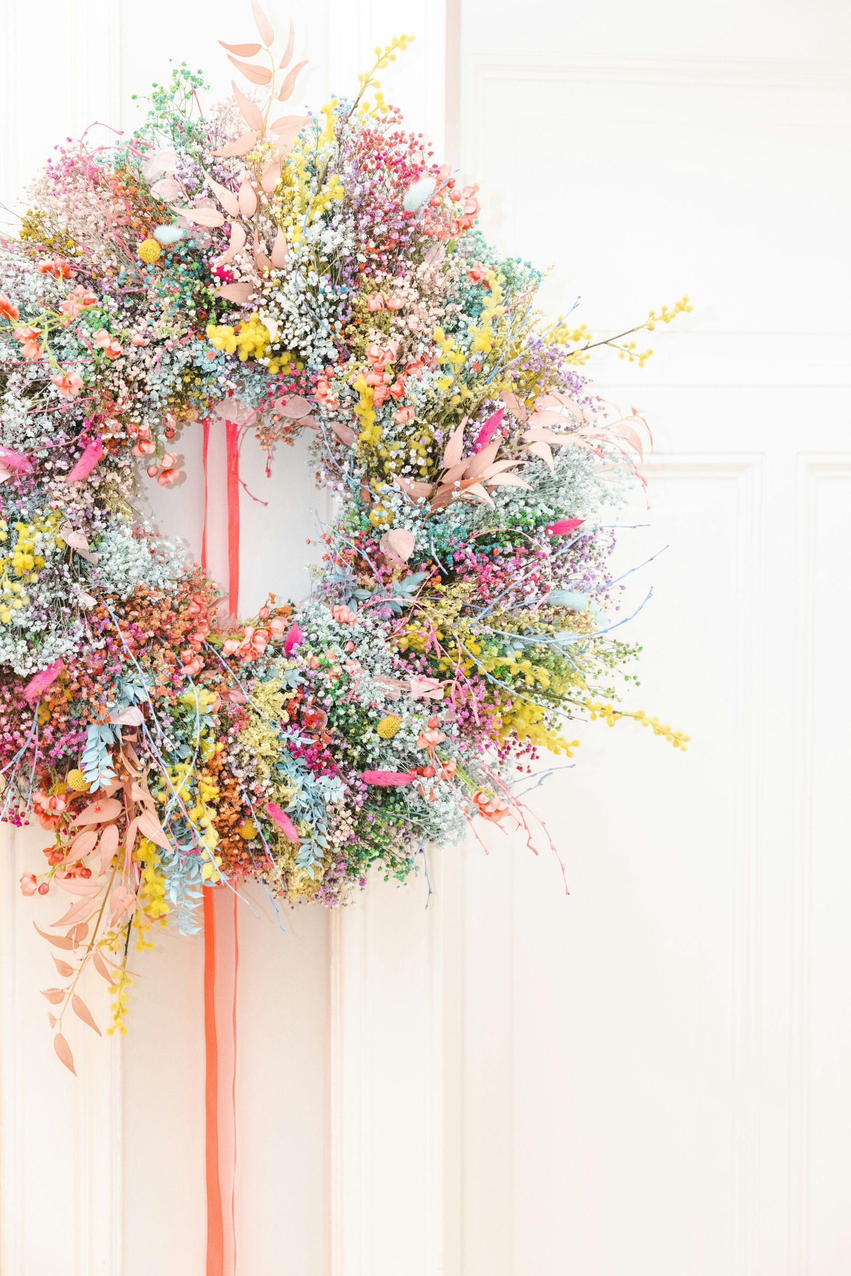 Colorful dried flower wreath with pink ribbon