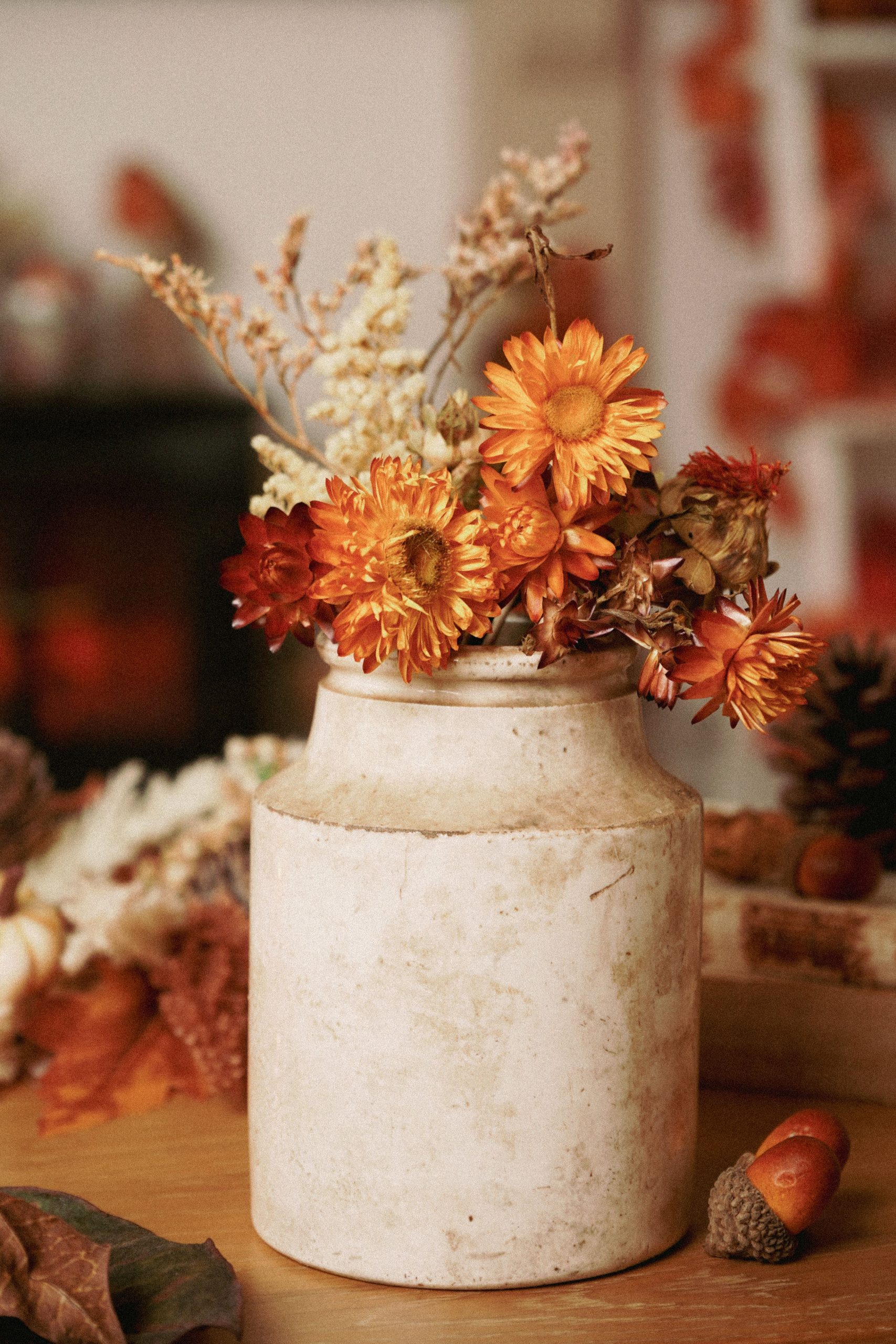 Cozy autumn floral arrangement in a vintage vase with dried flowers and warm tones.