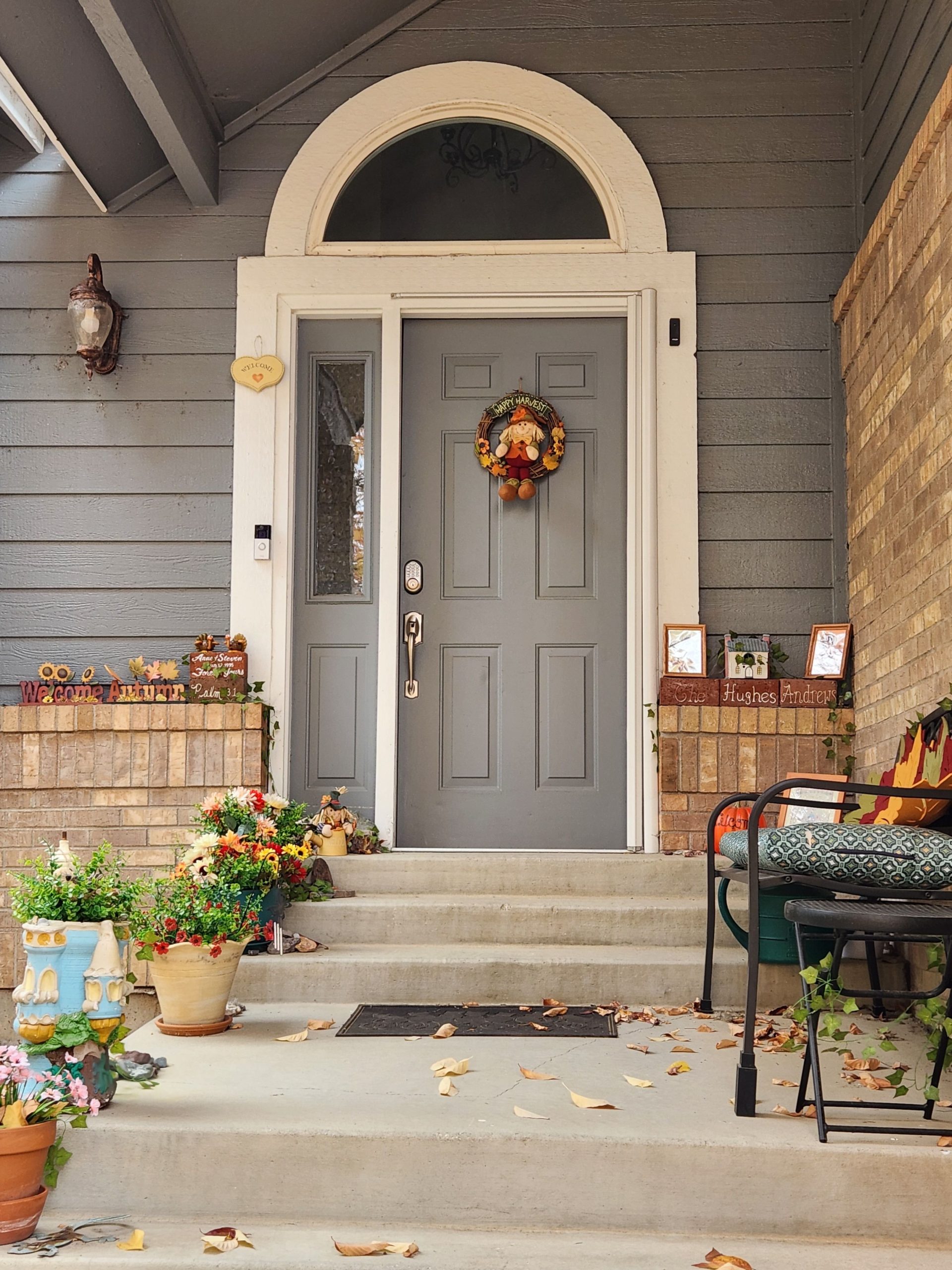 Cozy porch entrance adorned with autumn decor and colorful plants.