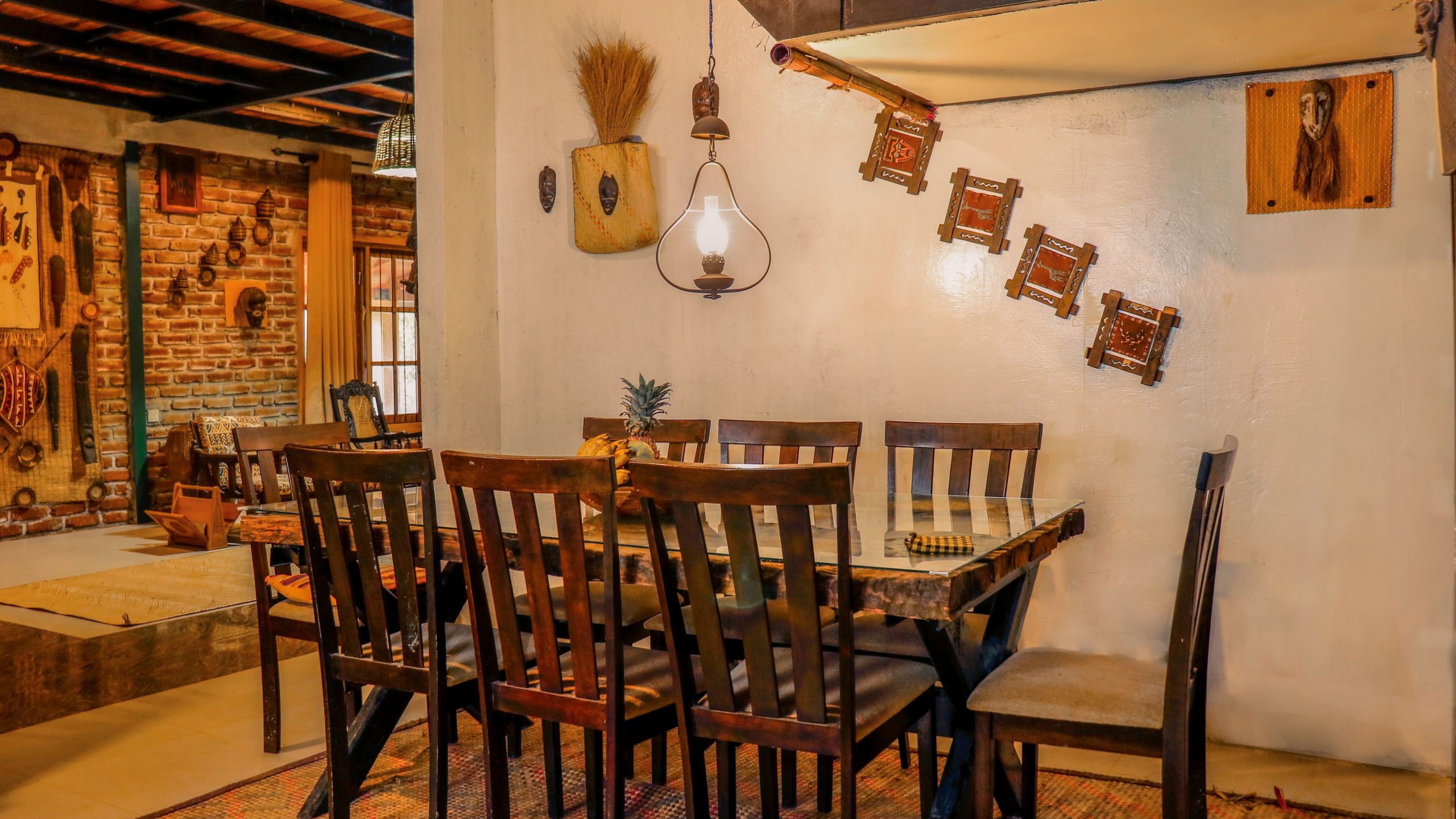 Cozy rustic dining room featuring wooden furniture, warm lighting and eclectic wall decor.