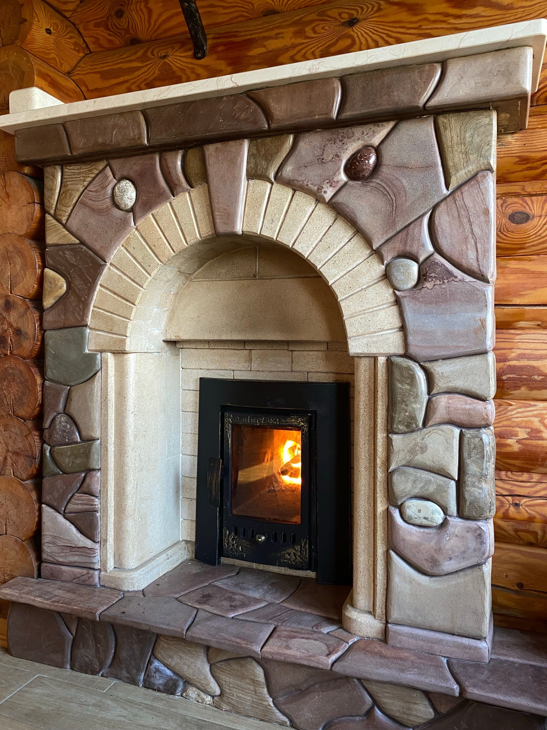 Cozy stone fireplace with a warm glow, creating a rustic and inviting atmosphere indoors.
