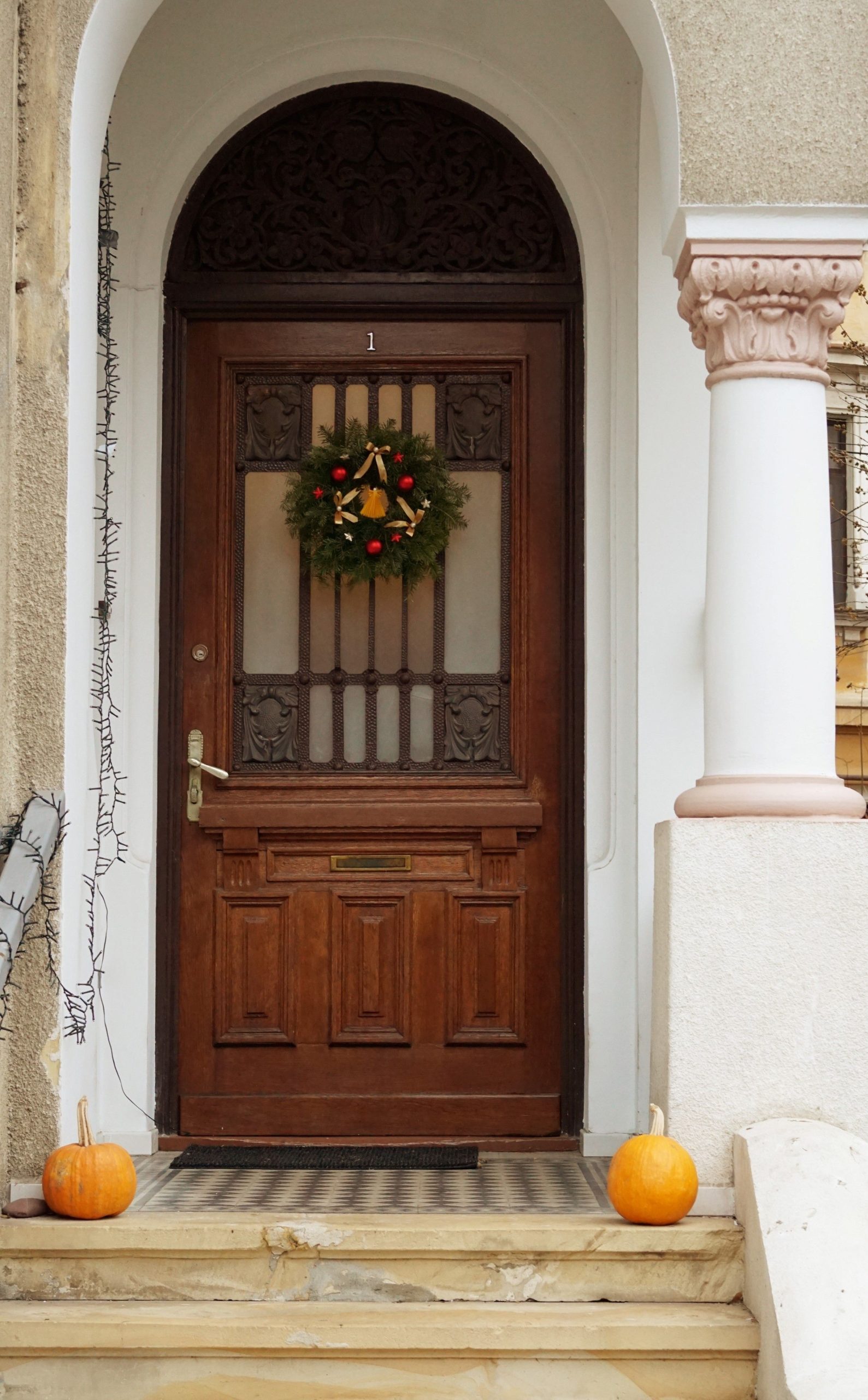 Cozy wooden door decorated with a festive wreath and pumpkins for a warm holiday feel.
