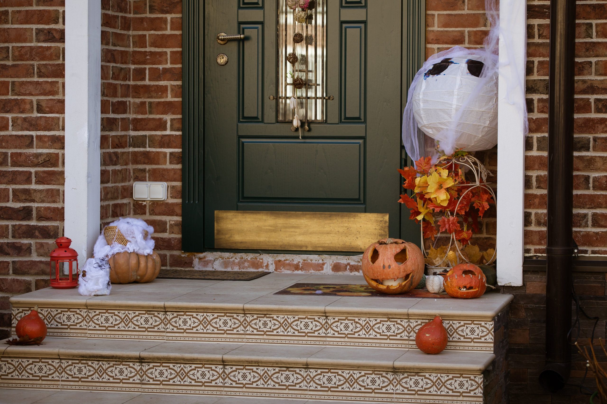 Decorated entrance featuring carved pumpkins and autumn leaves, perfect for Halloween celebrations.