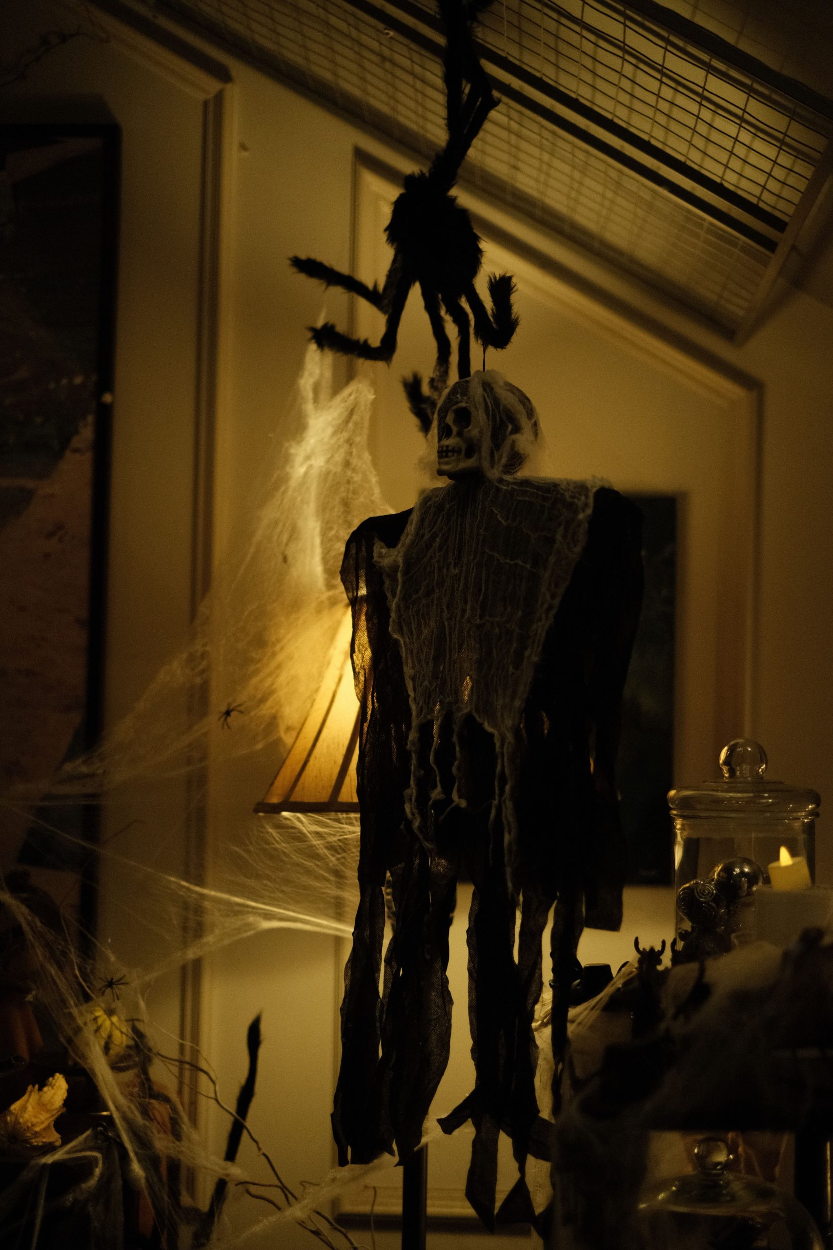 Eerie Halloween scene featuring spooky skeleton decor with cobwebs and dim lighting.