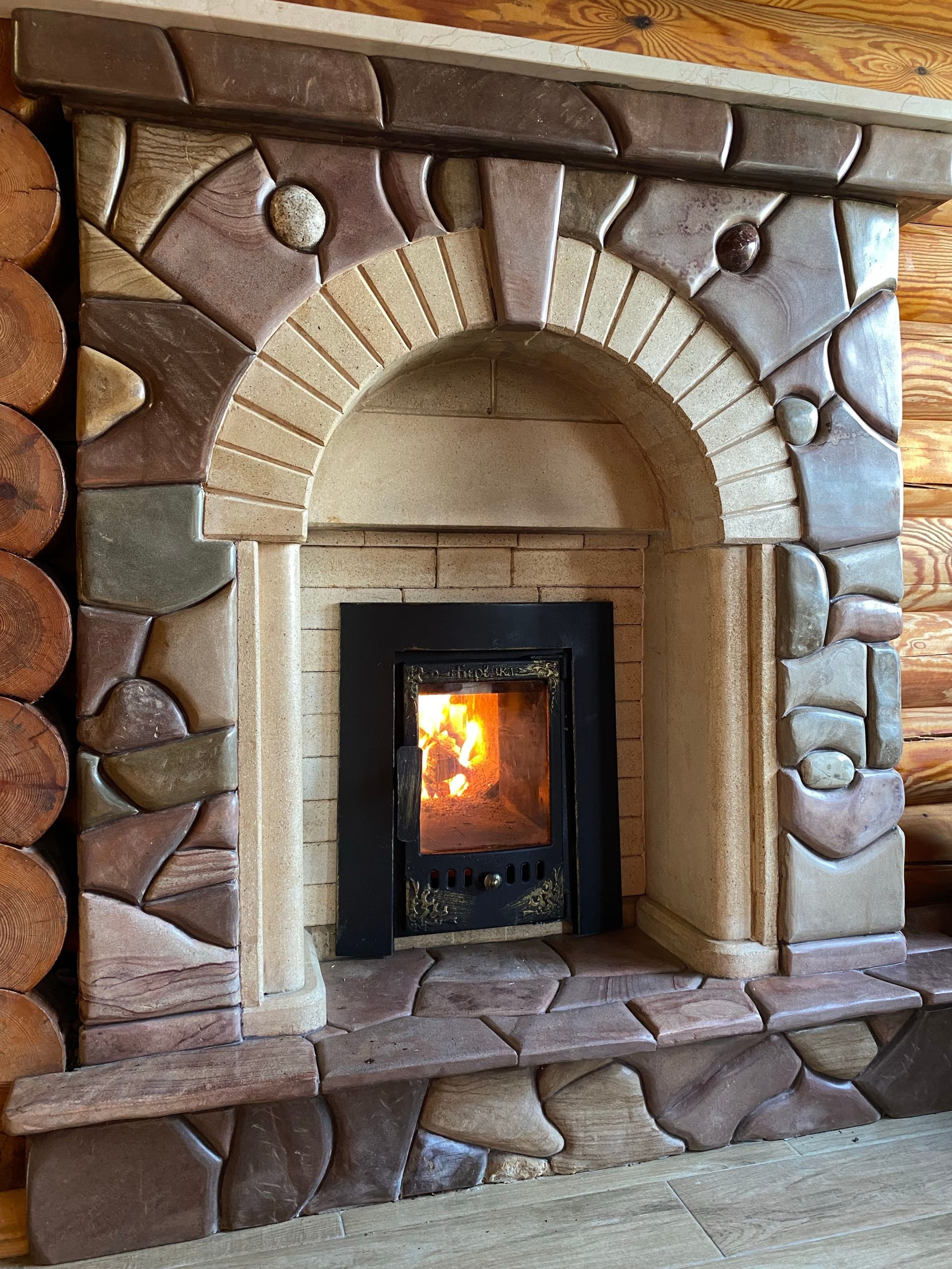 Inviting fireplace with warm stone arch, perfect for a cozy indoor setting.