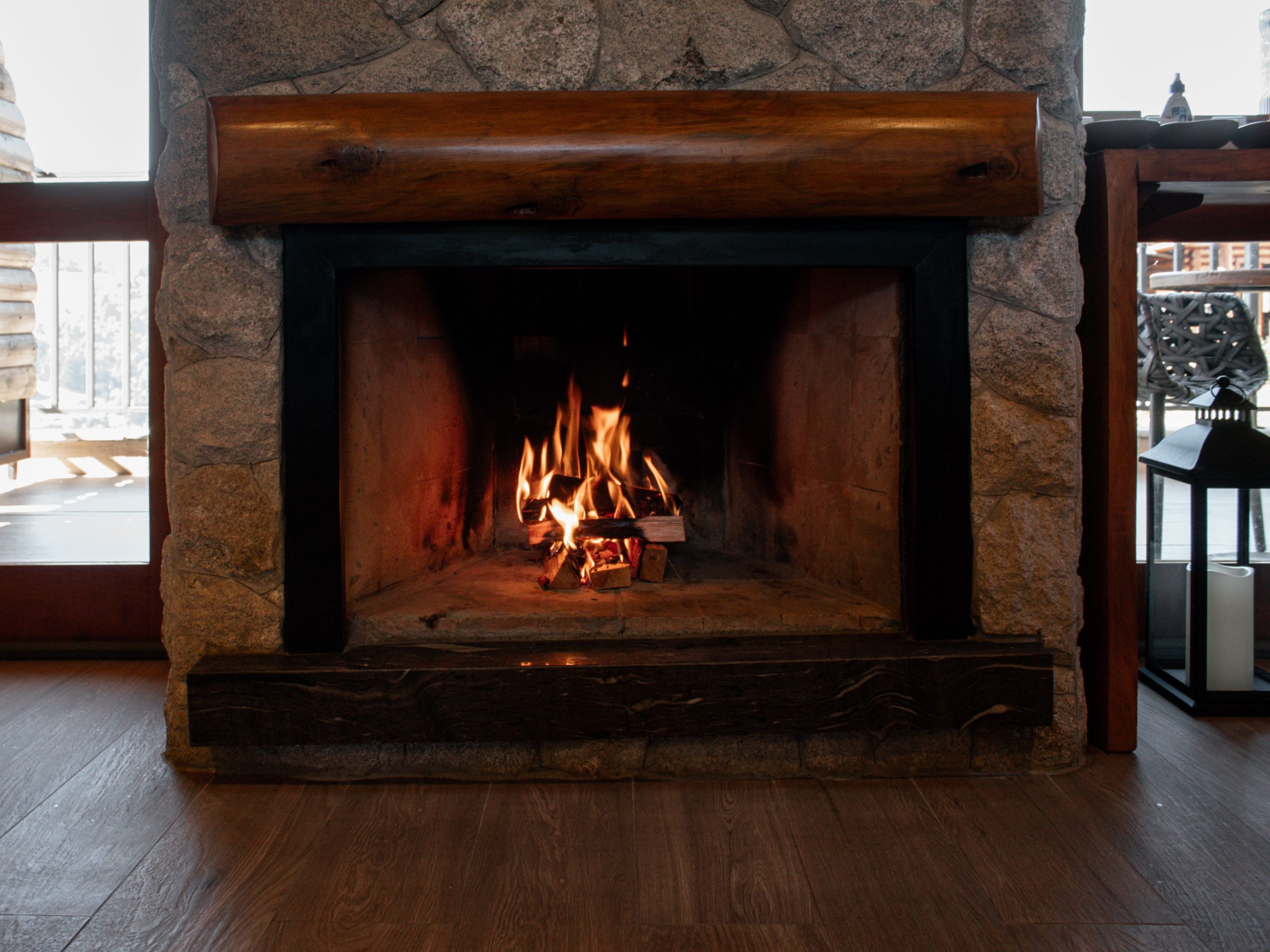 Inviting stone fireplace with a roaring fire, perfect for warming up indoors in winter.
