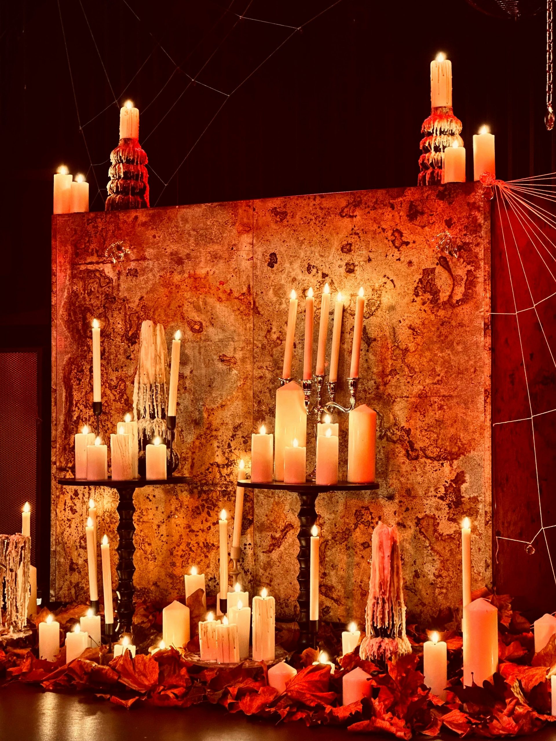 Many lit candles on a rustic display