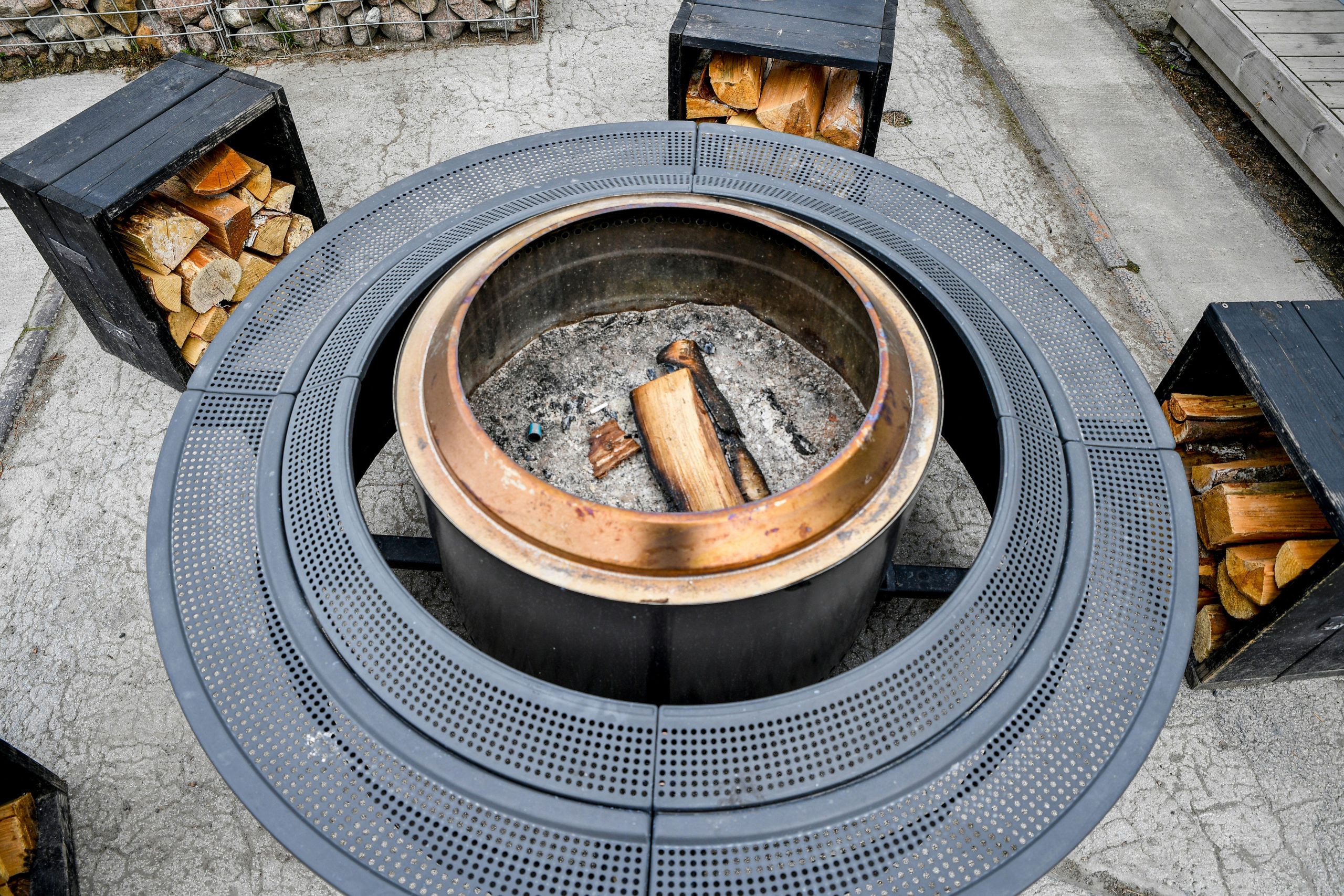 Nordic Coziness: A modern circular outdoor fire pit with stacked firewood at Iglupark in the Noblessner district of Tallinn, Estonia.