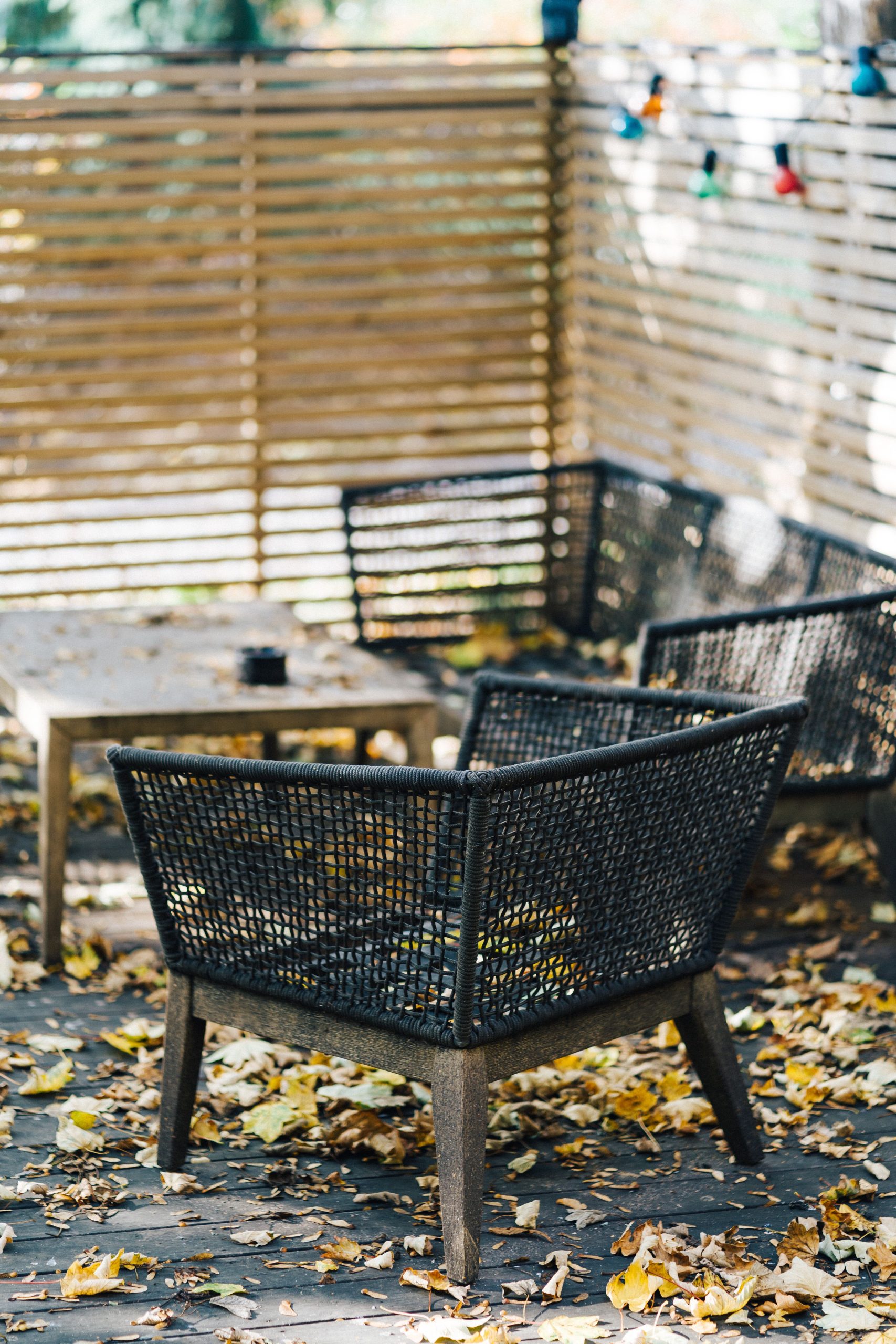 Outdoor patio furniture surrounded by autumn leaves in a cozy Oslo garden setting.