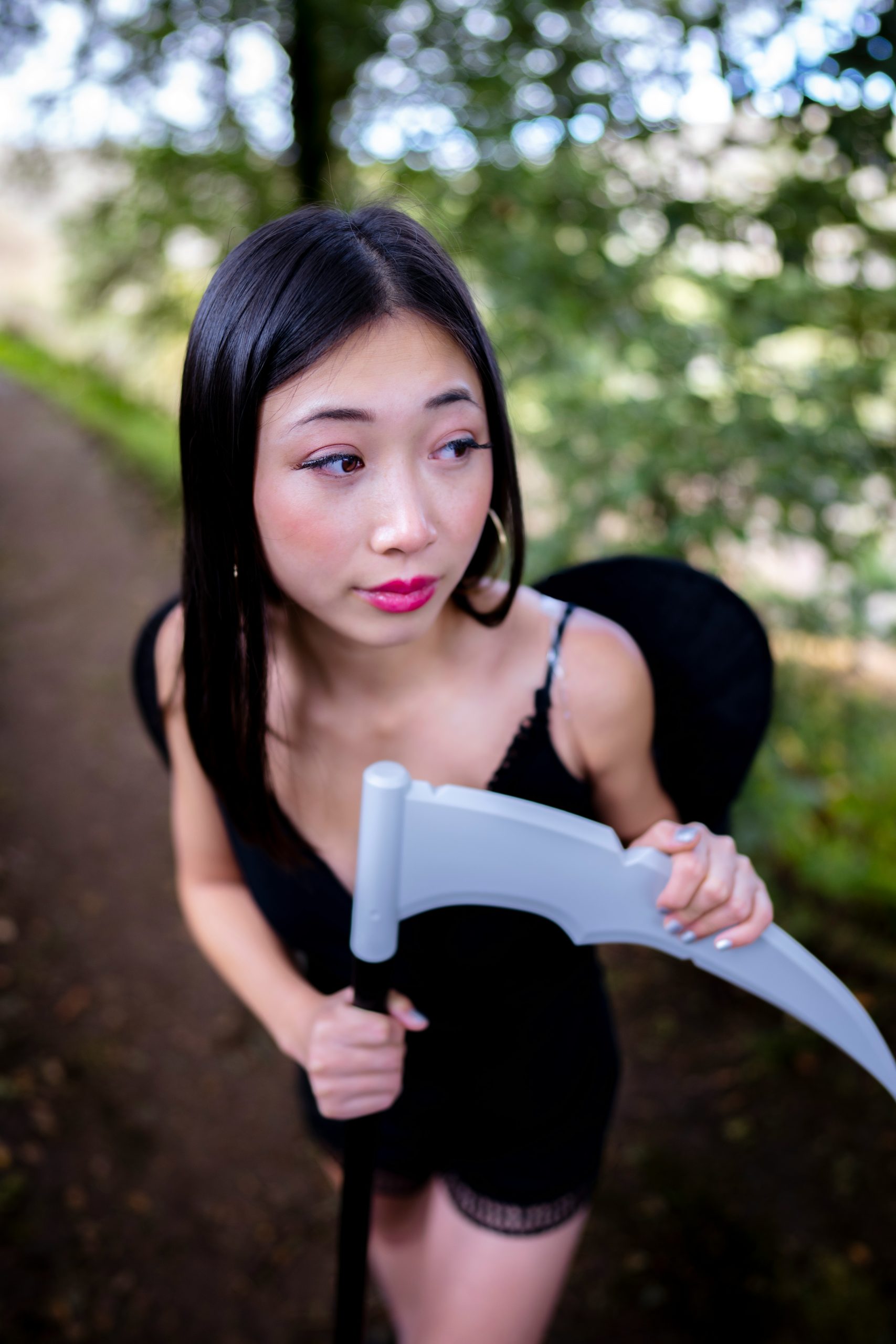 Portrait of a Young Asian Woman Wearing a Grim Reaper Costume in the Woods