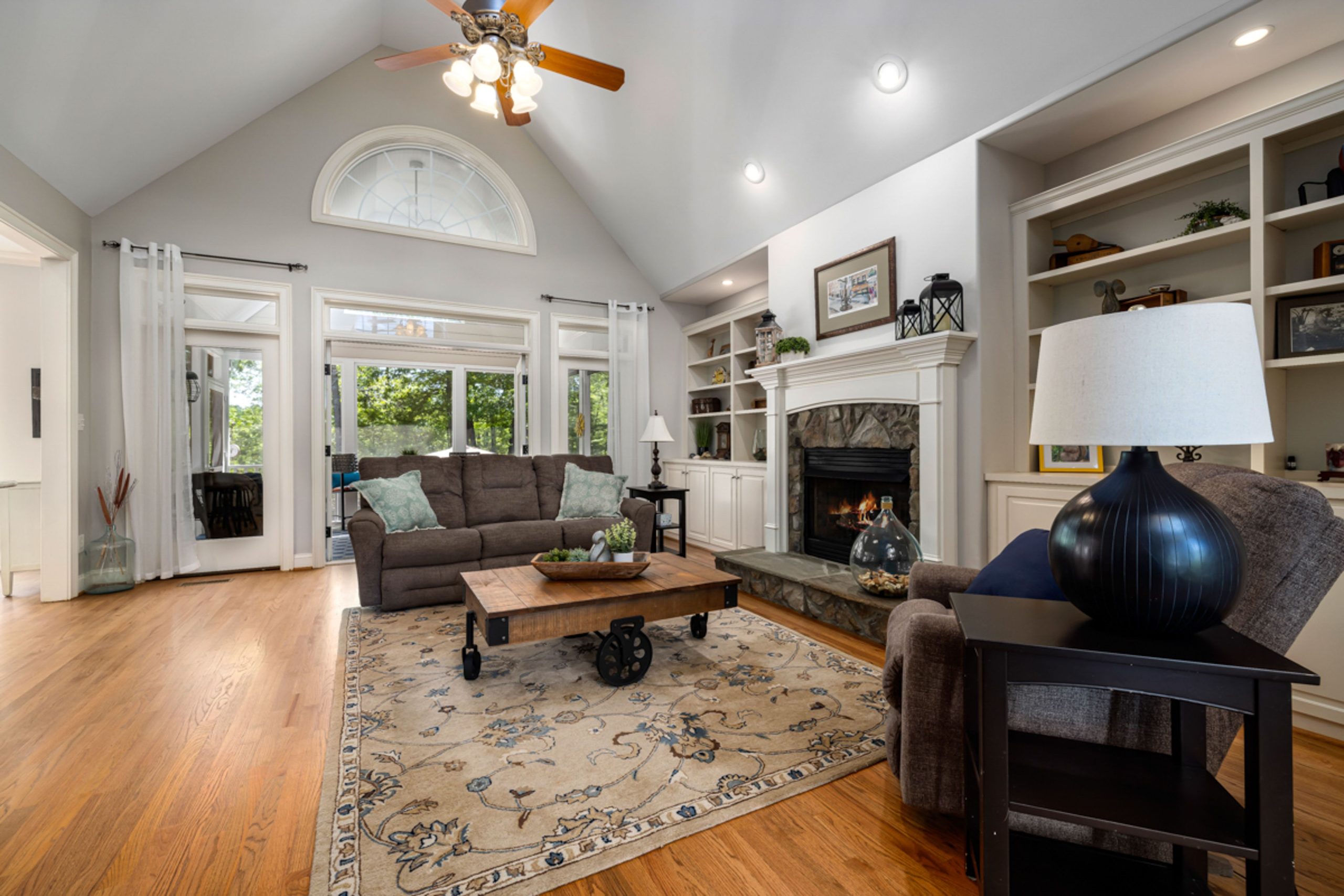 Spacious and elegant living room featuring a stylish fireplace, neutral tones, and ample natural light.