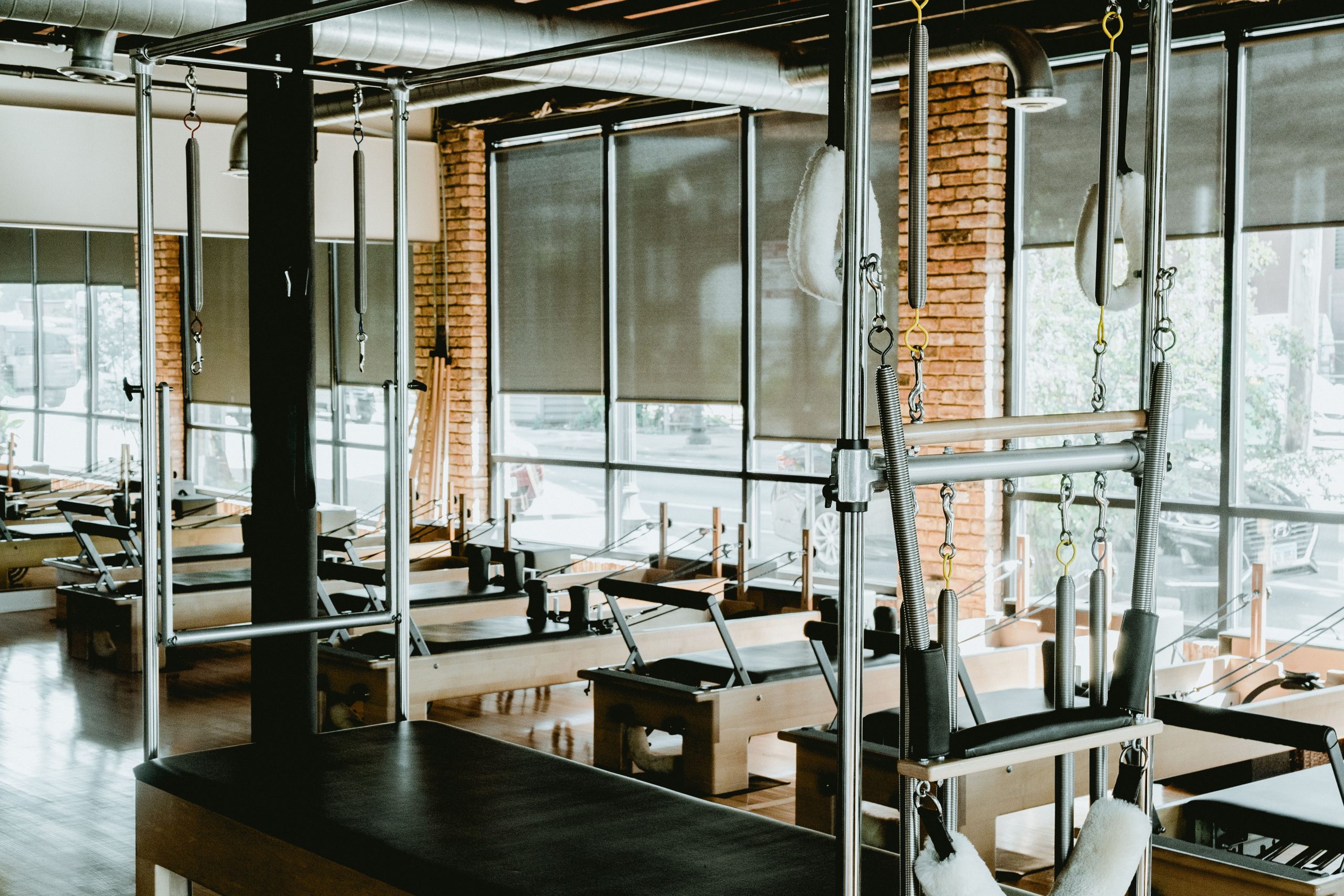 Spacious and well-equipped Pilates studio featuring reformers and other fitness equipment.