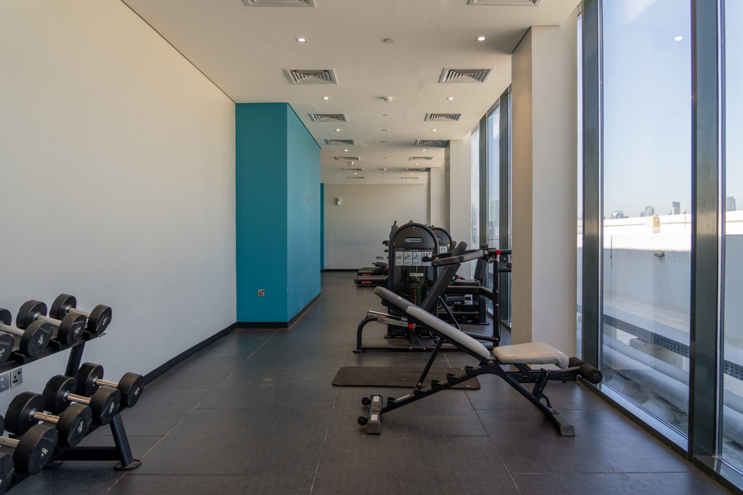 Spacious gym with exercise machines and dumbbells, perfect for bodybuilding and fitness enthusiasts.