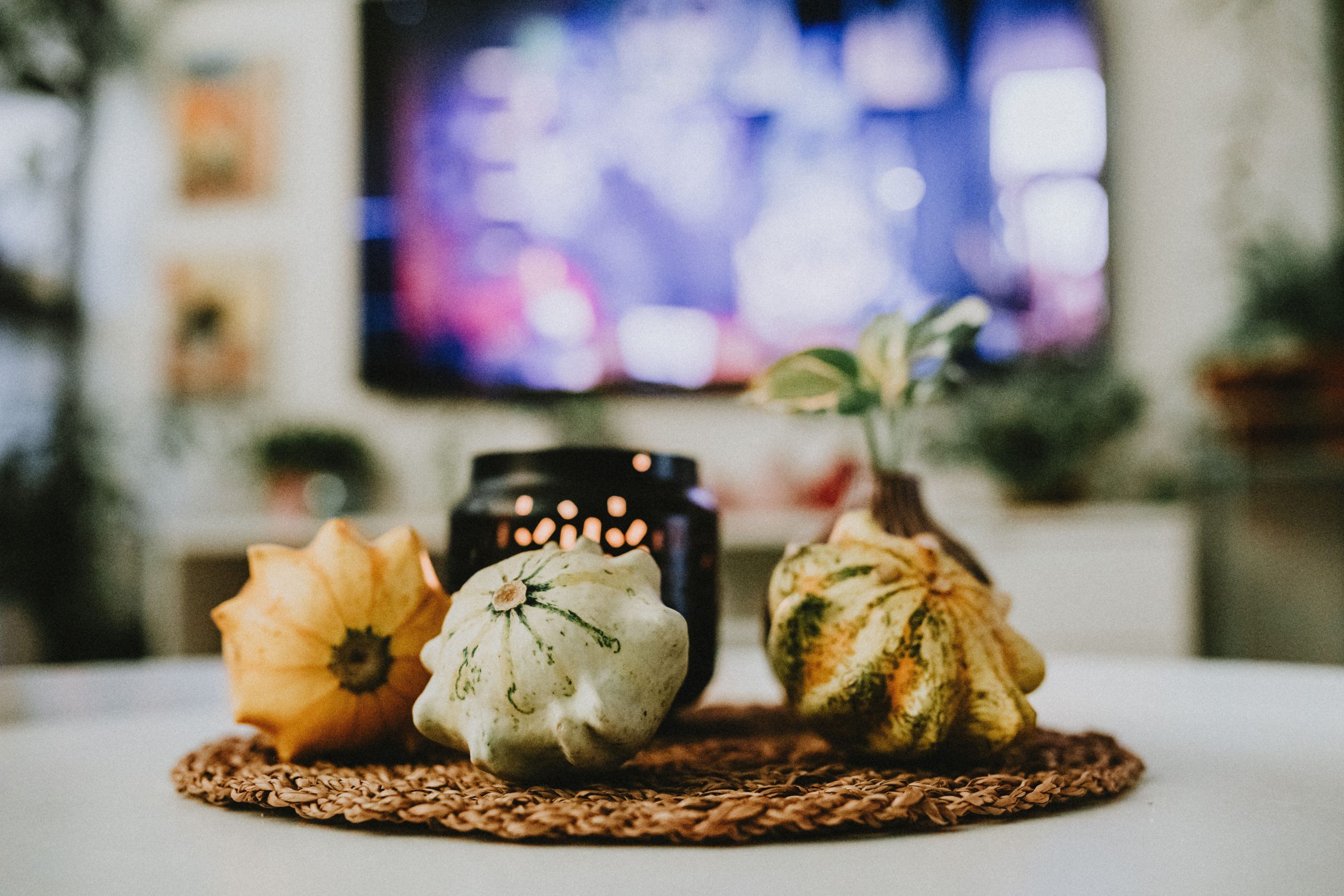 Stylish autumn decoration with pumpkins and candles in a cozy living room setting.