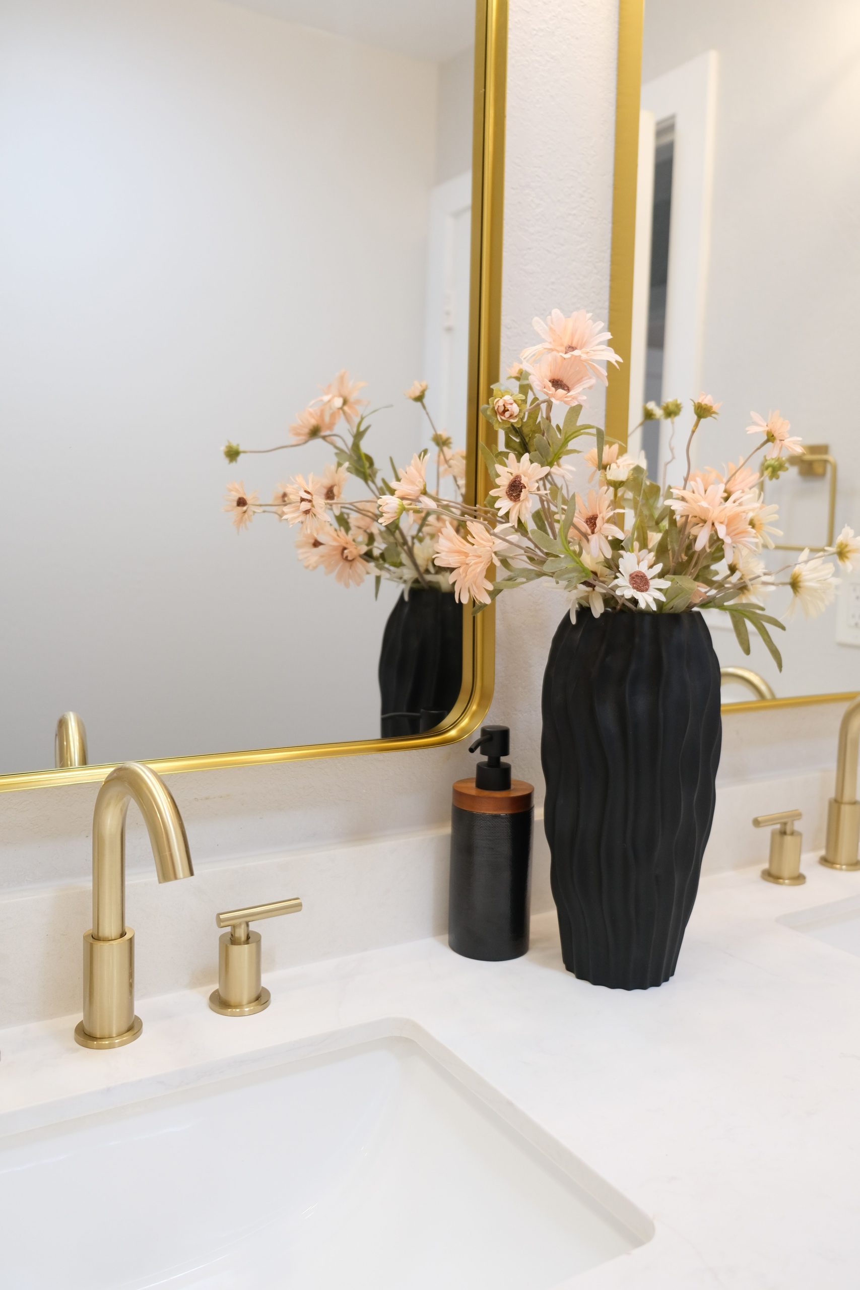 Stylish bathroom vanity with a floral arrangement and modern fixtures.