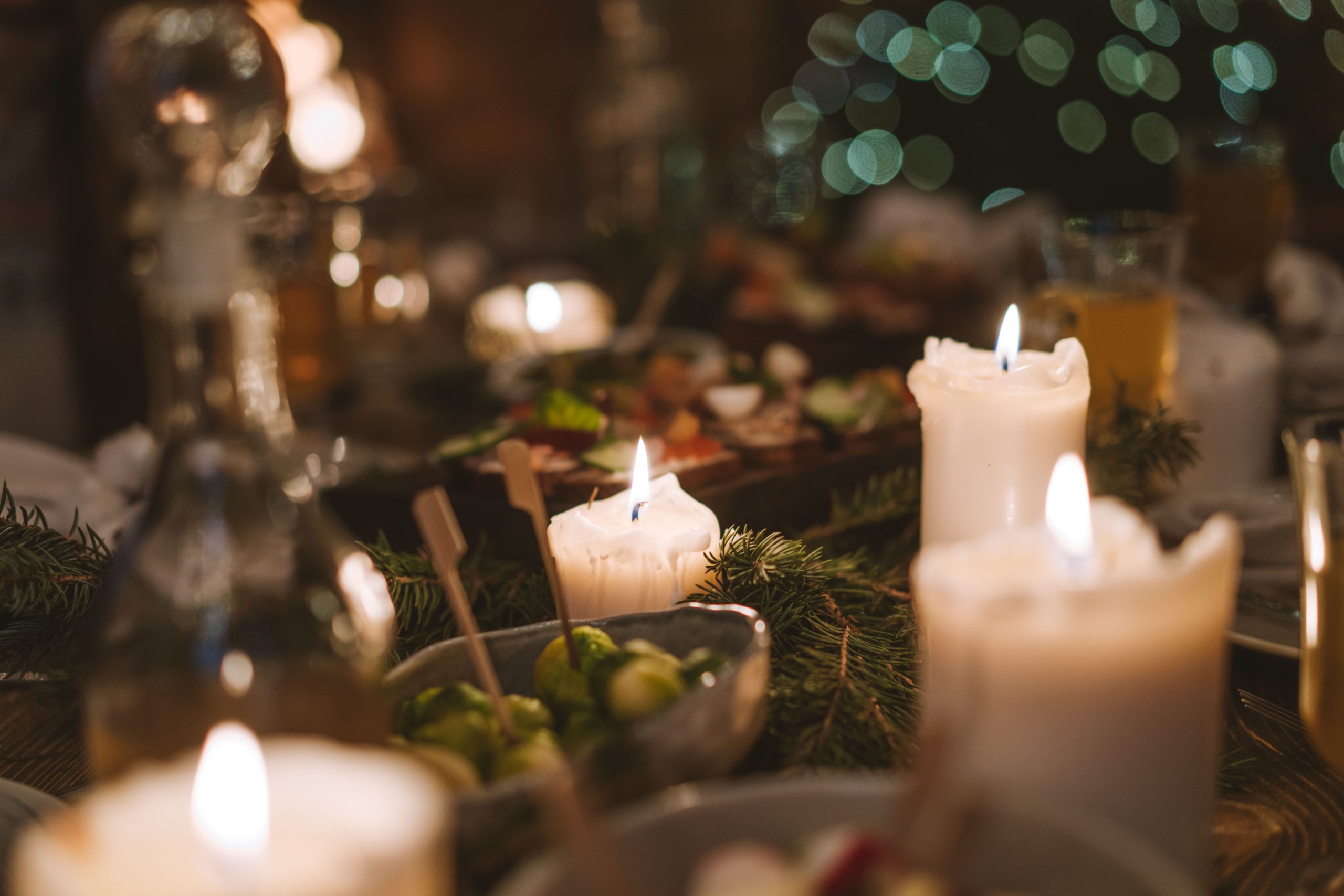 Warm ambiance of a candlelit dining table with festive decorations and food, perfect for holidays.