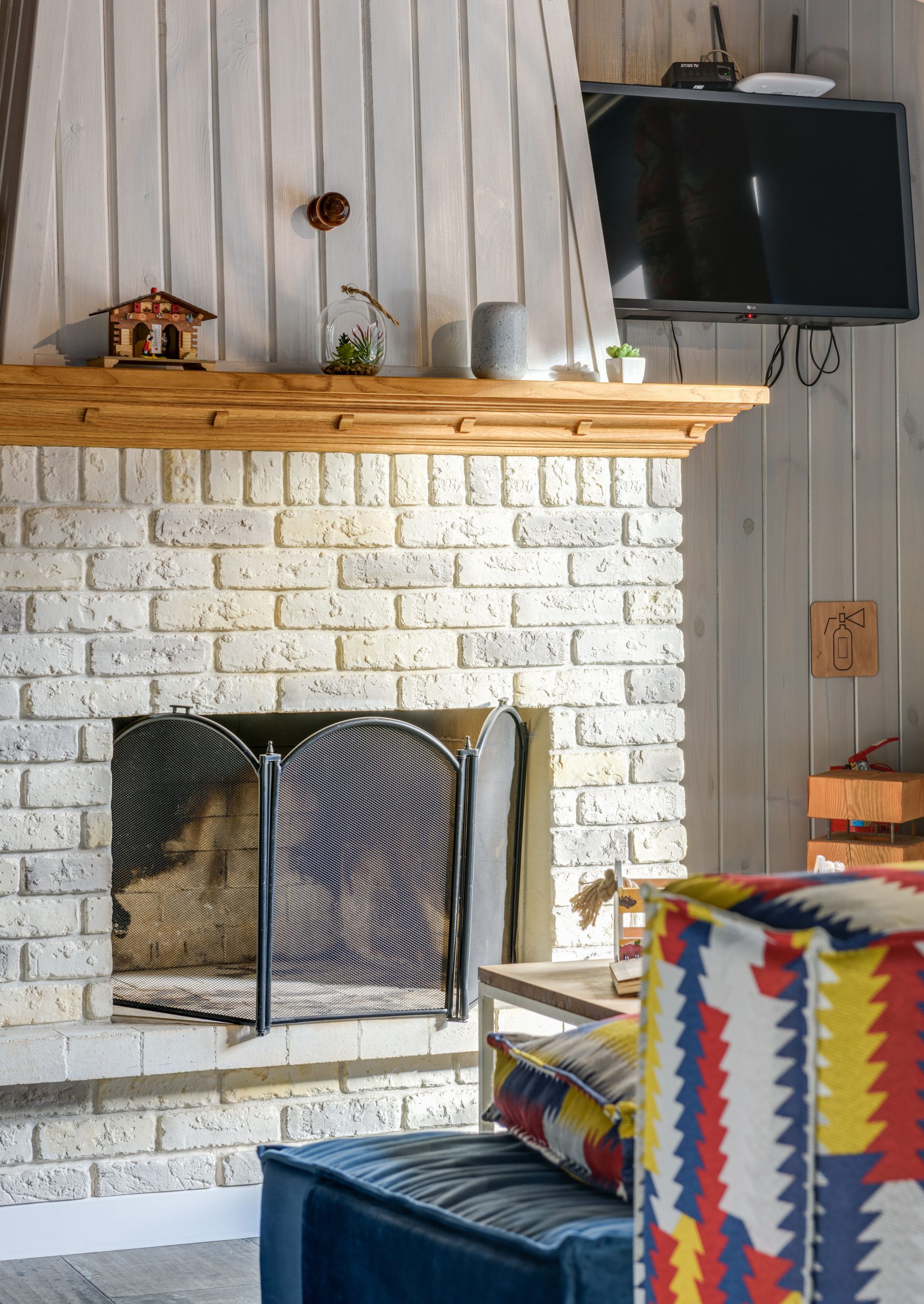 Warm and inviting living room with a brick fireplace and wall-mounted TV.