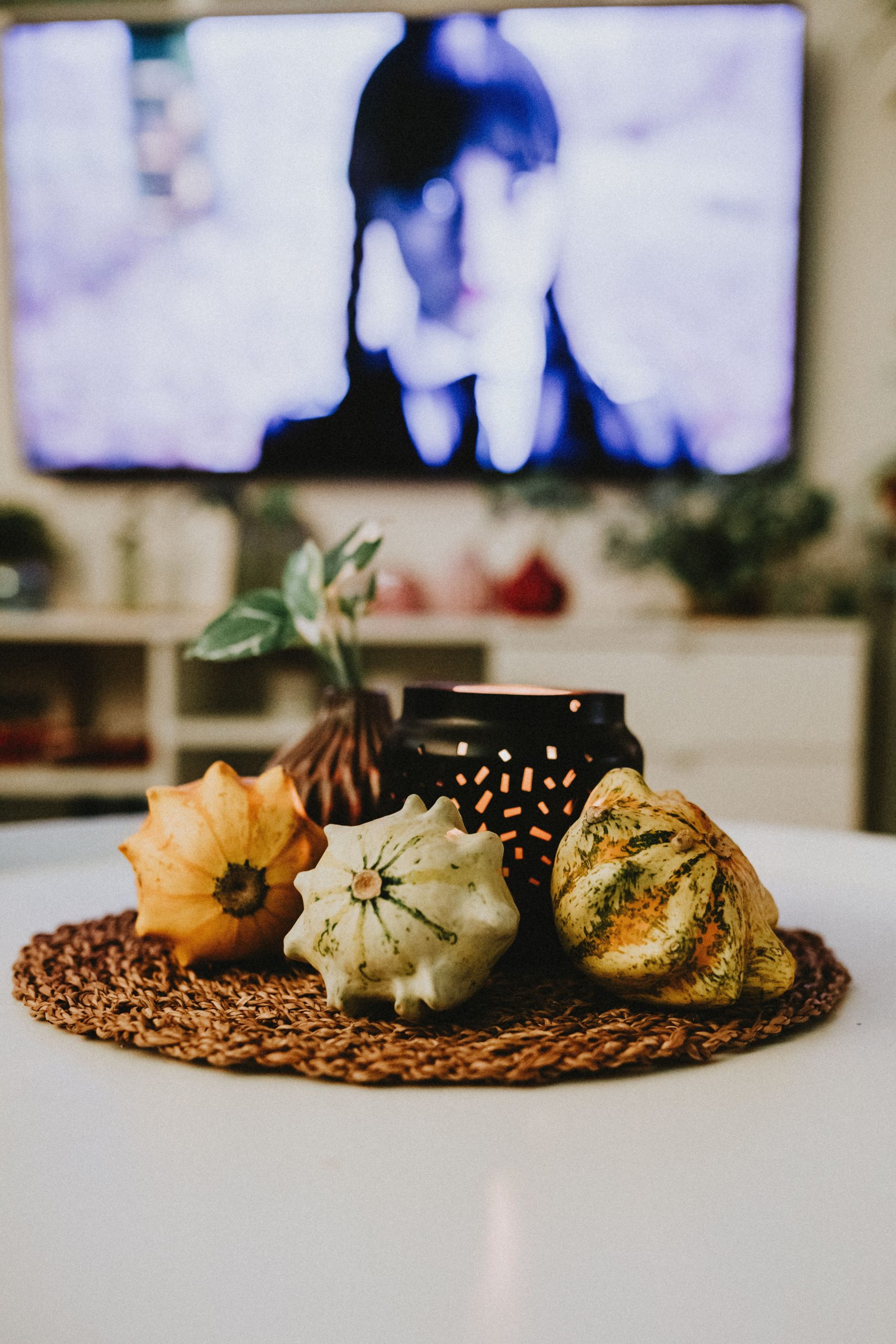 Warm autumn living room scene featuring decorative pumpkins and candle on a table.