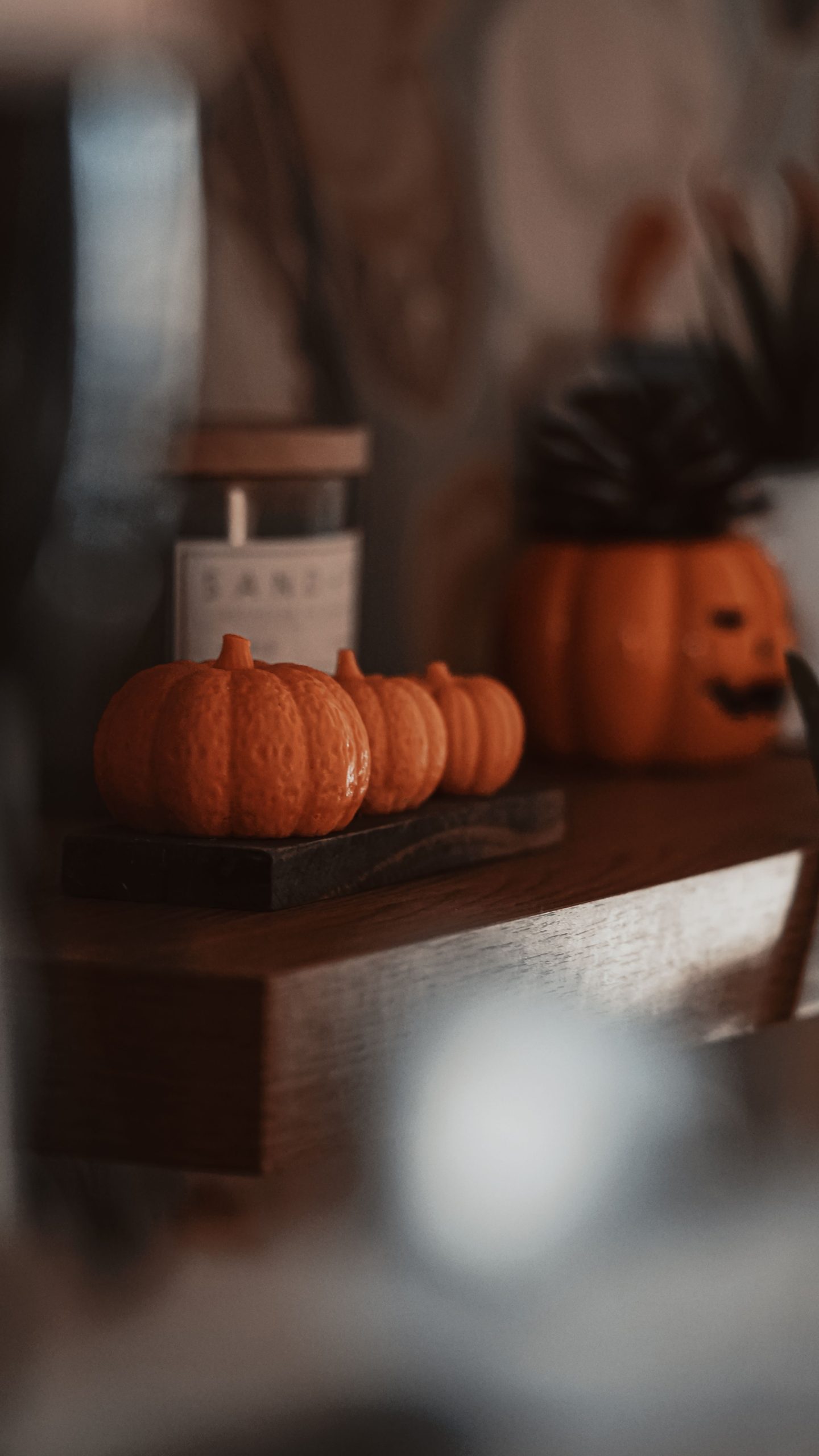 Warm autumn-themed still life featuring pumpkins and Halloween decor indoors.