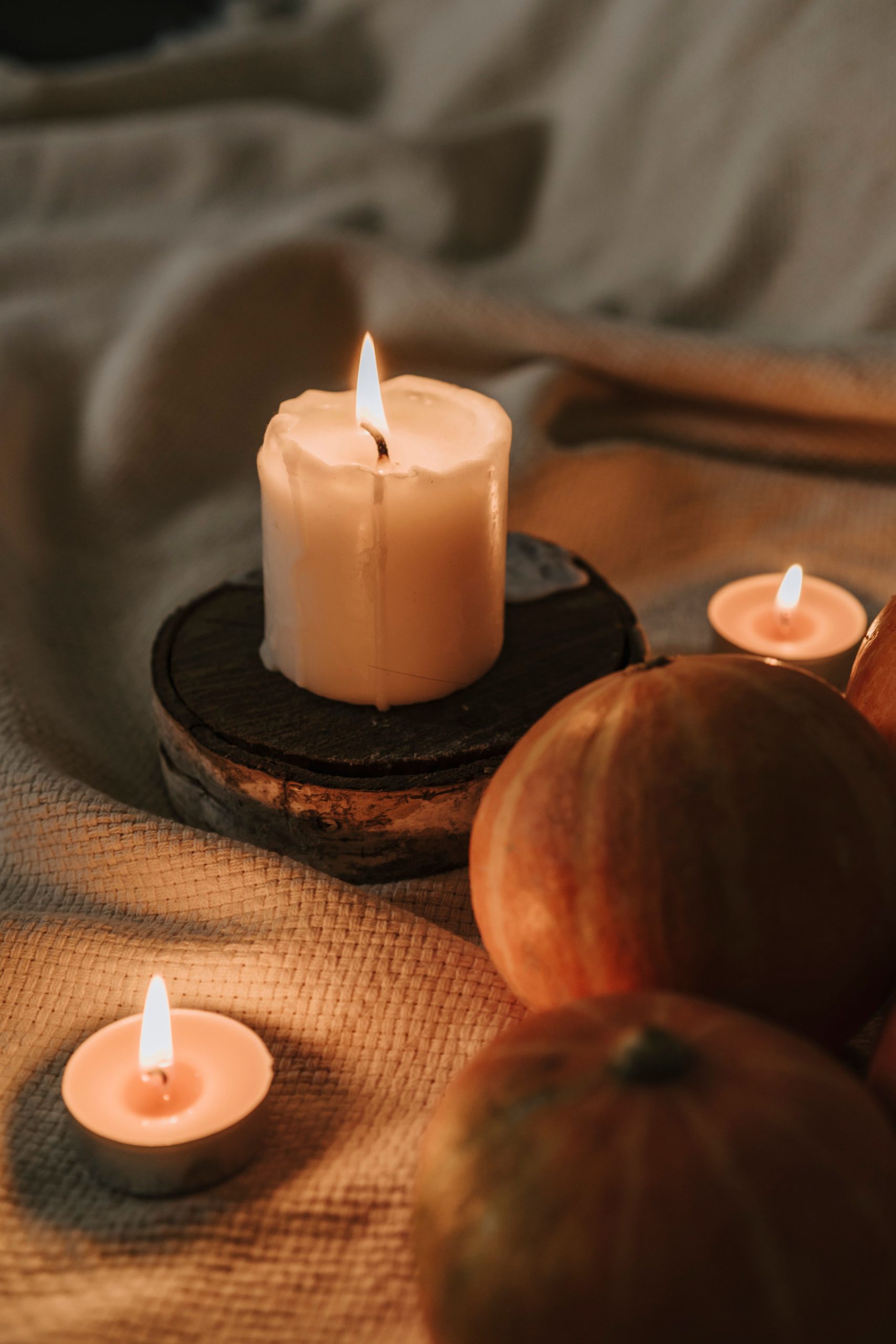 Warm candlelight with pumpkins creates a cozy autumn atmosphere perfect for Halloween.
