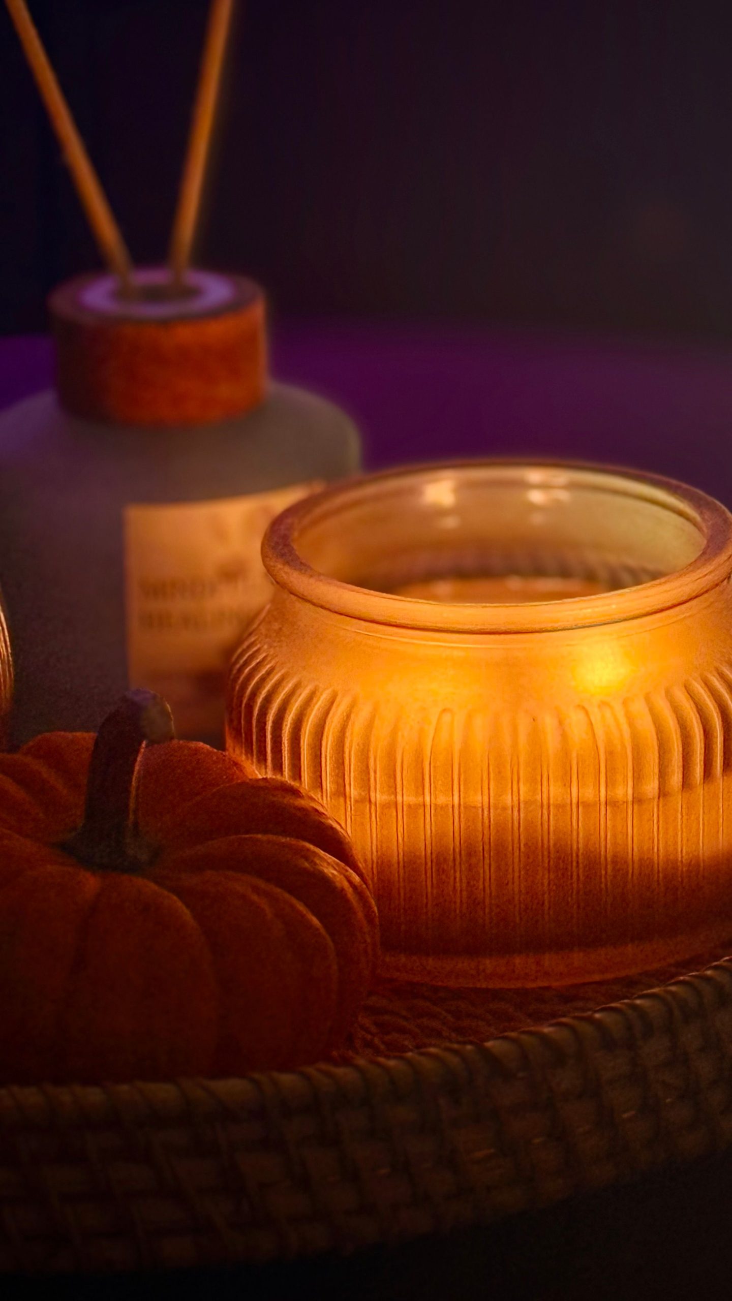 Warm candlelit setup with a pumpkin and cozy autumn vibes.