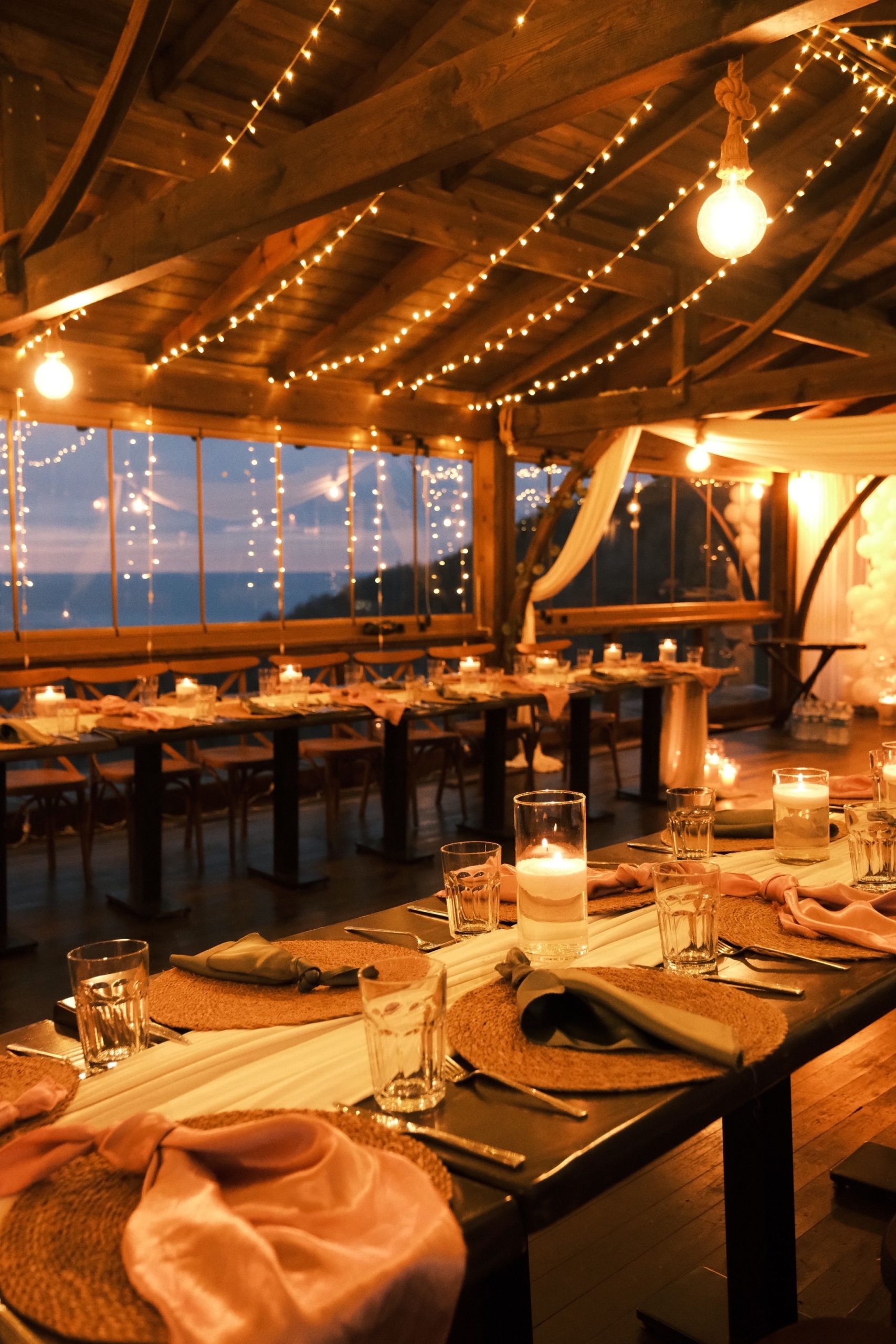 Warm, cozy dining setup with string lights and candles for an intimate ambiance.