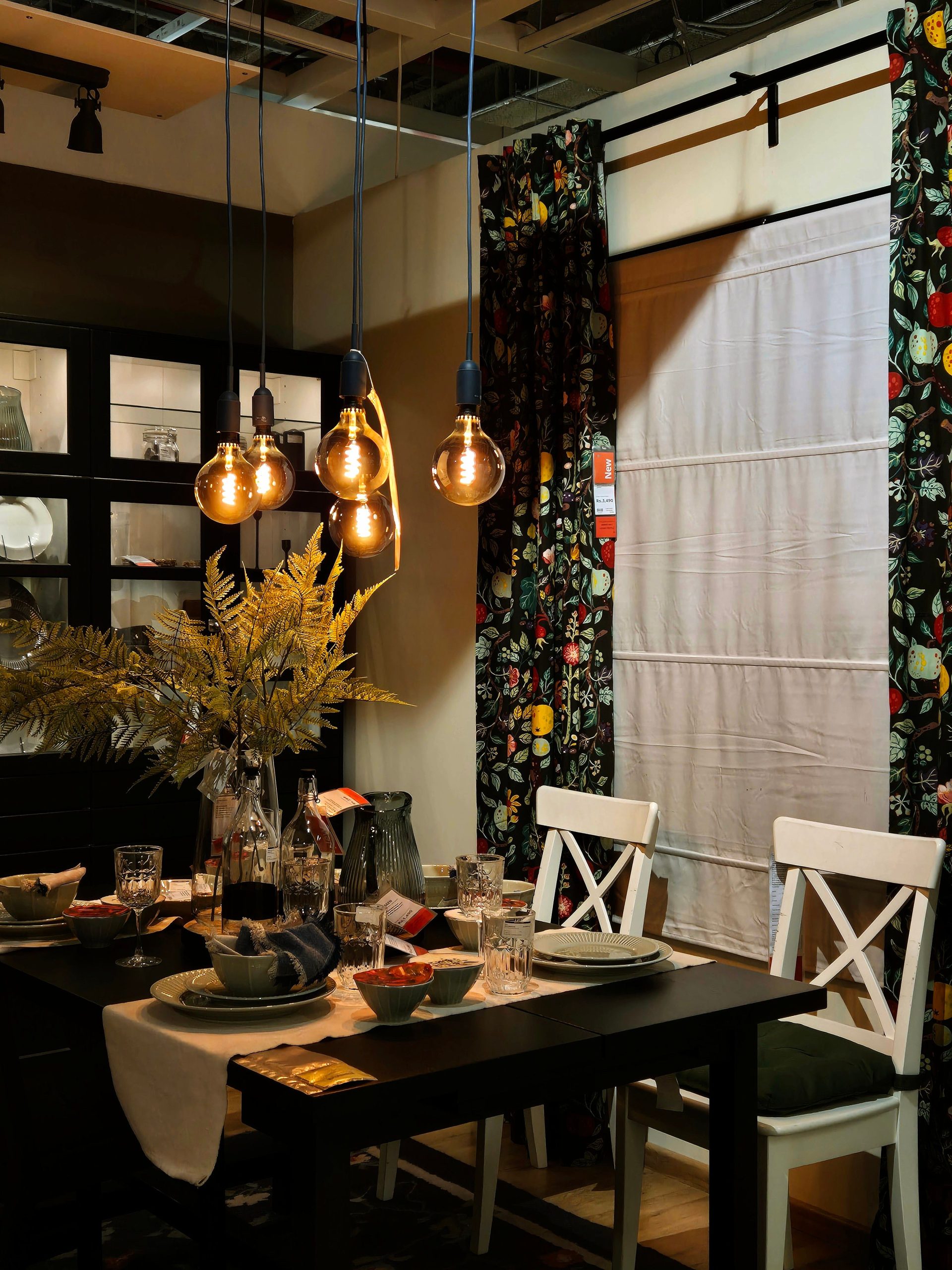 Warm dining room interior with modern fixtures, table setting, and decorative plants in Bengaluru, India.