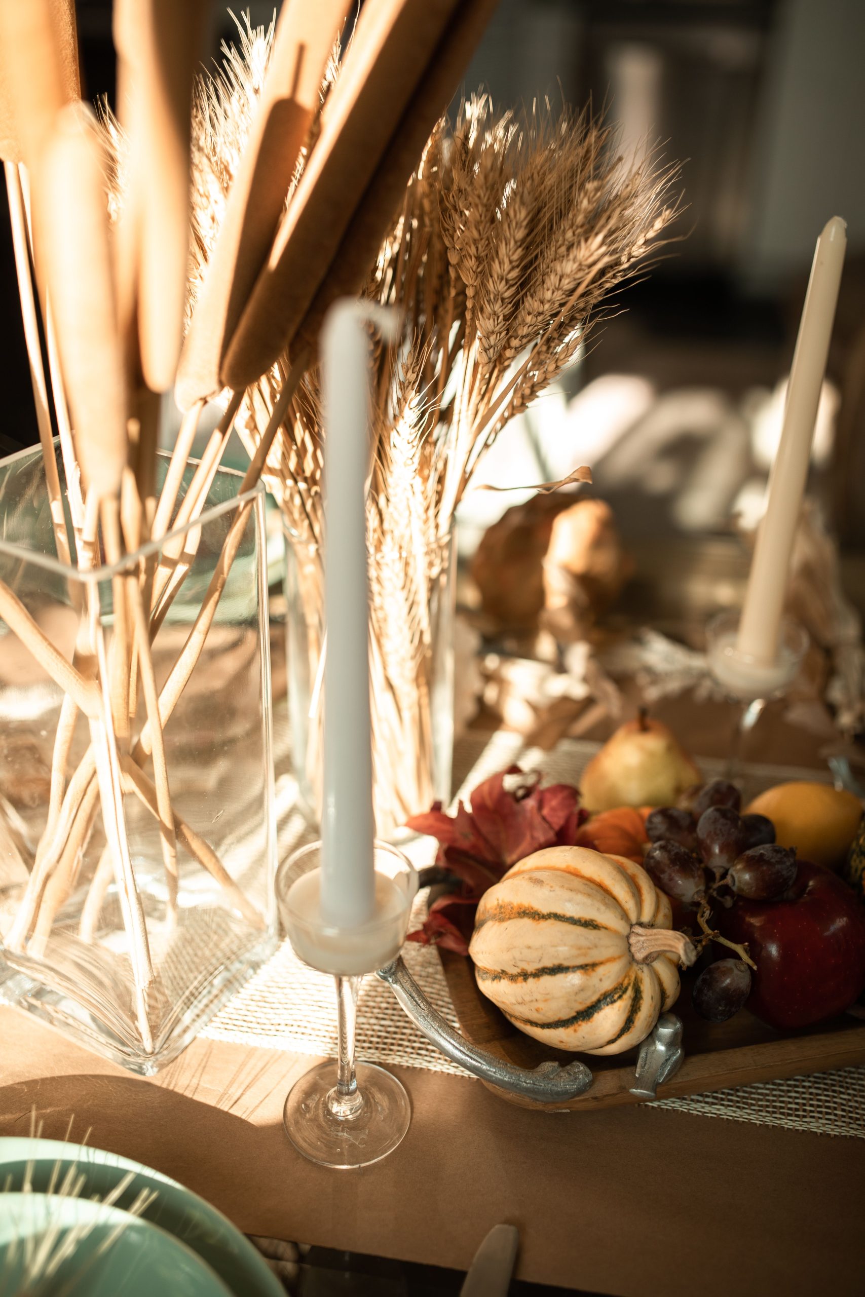 Warm harvest-themed table setting featuring candles and gourds, ideal for fall celebrations.