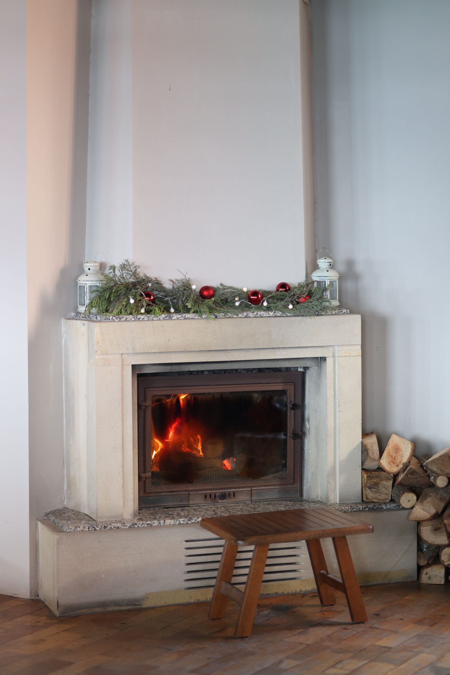 Warm indoor fireplace decorated for the holidays, creating a festive atmosphere.