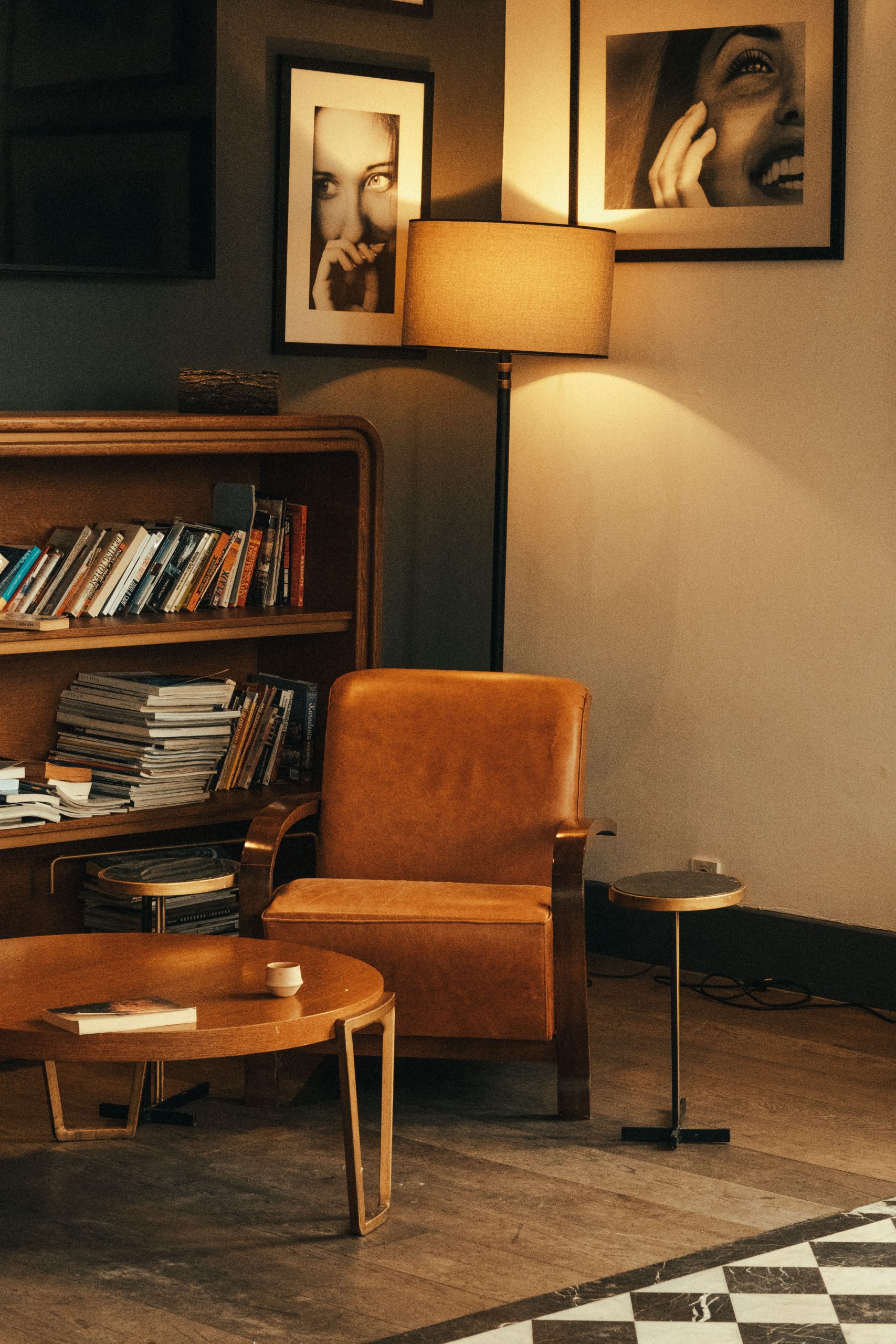 Warm inviting reading nook with leather chair, bookshelf, and ambient lighting for cozy relaxation.