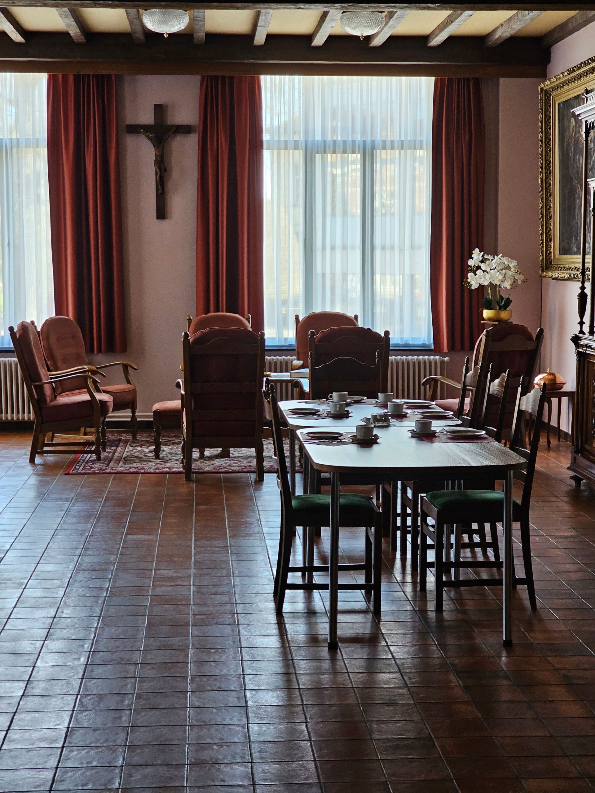 Warm living room with dining table, chairs, and vintage decor. Cozy and inviting setting.