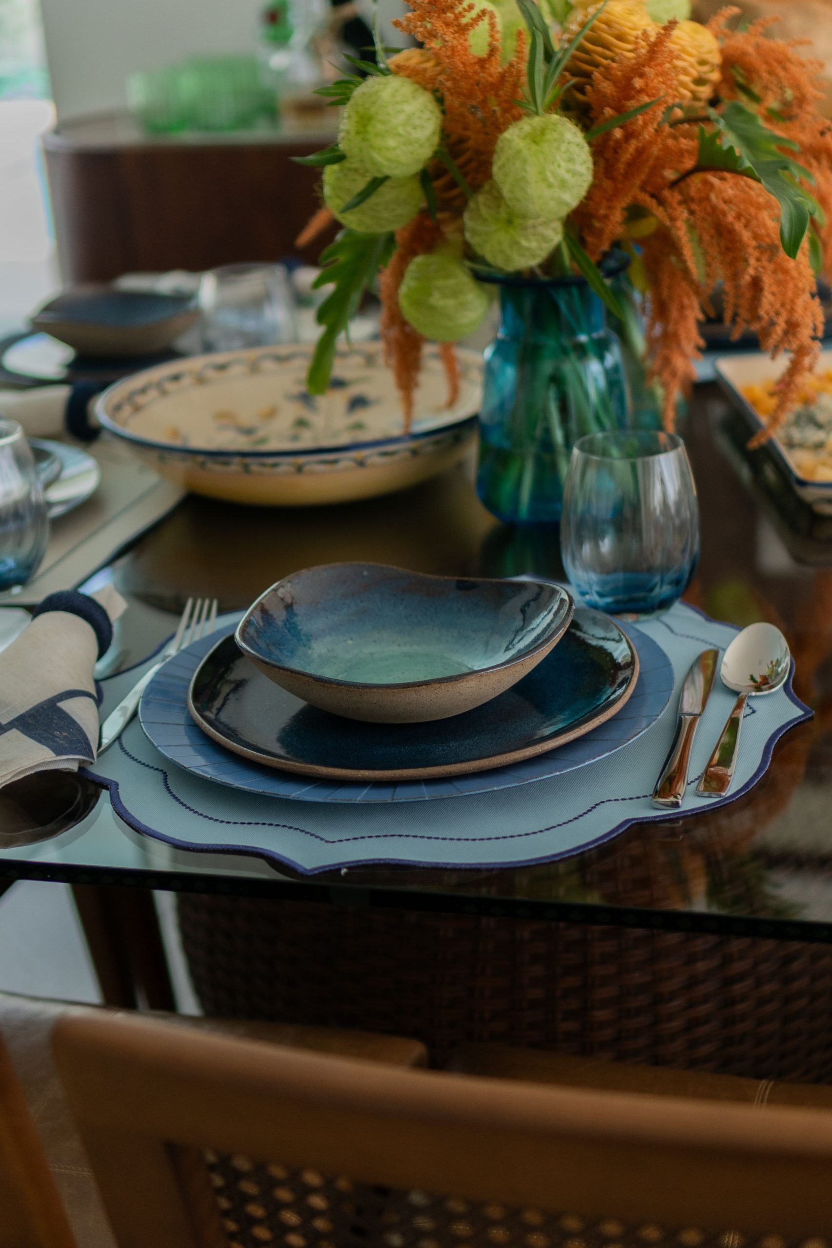 A beautifully set dinner table with vibrant floral centerpiece, rich tableware, and elegant decor, perfect for gatherings.