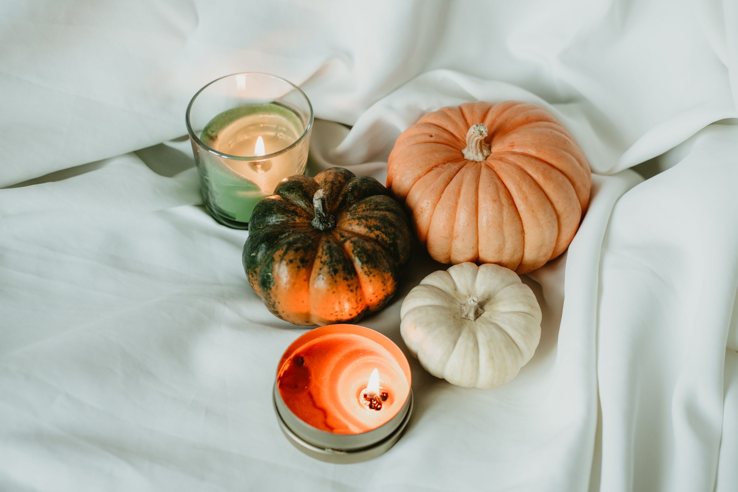 A cozy arrangement of pumpkins and candles perfect for autumn decor inspiration.