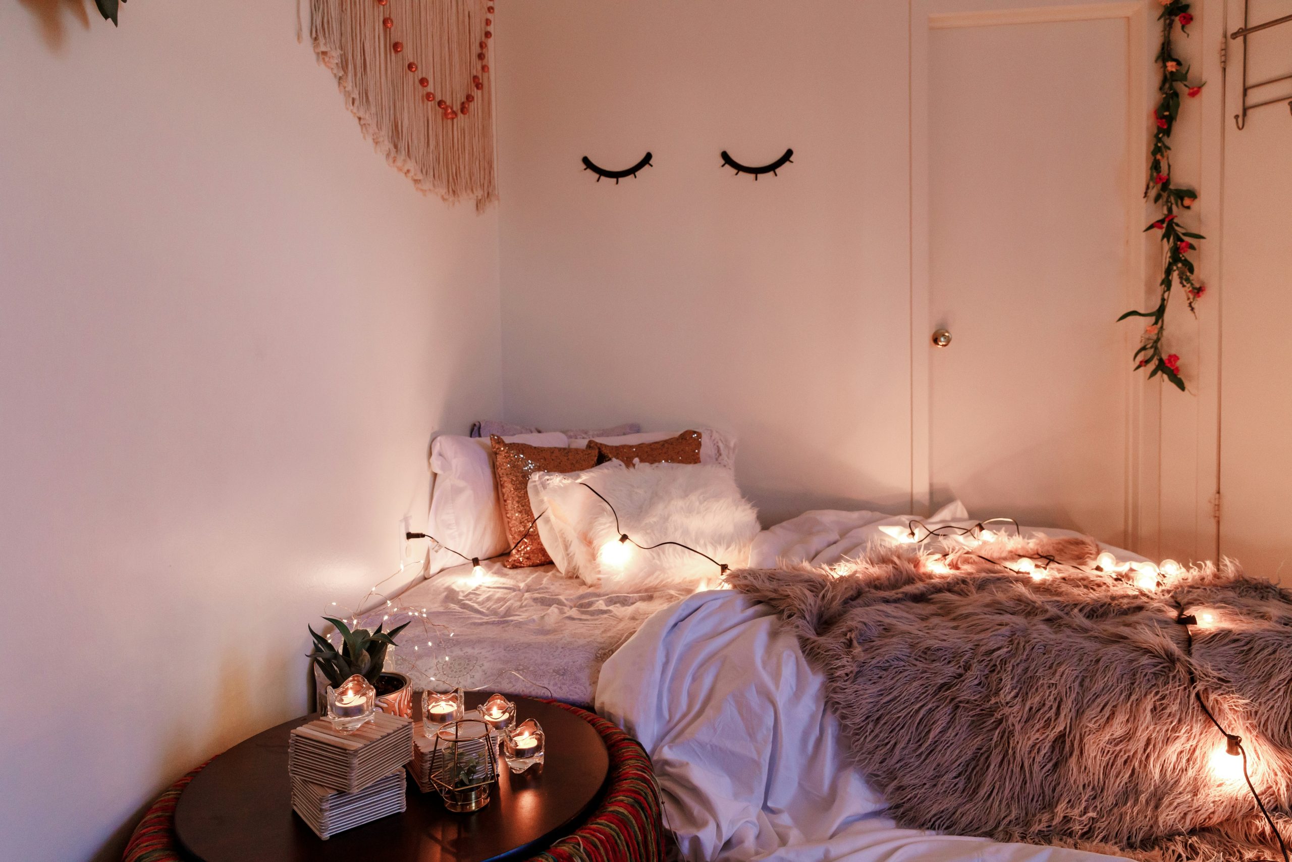 a cozy boho room decor with candles and string lights