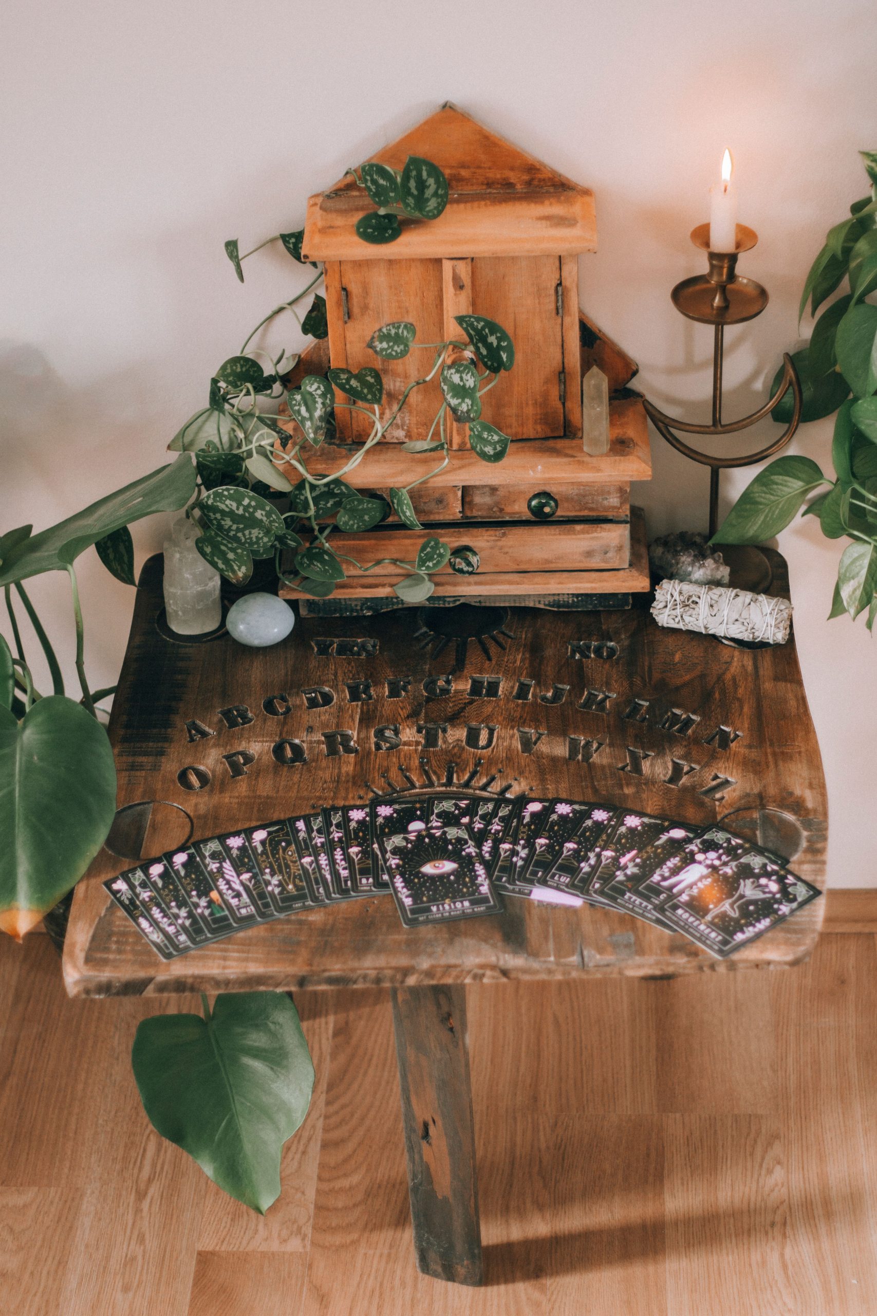 A mystical setup with tarot cards, a wooden board, and candle ambiance, perfect for spiritual exploration.