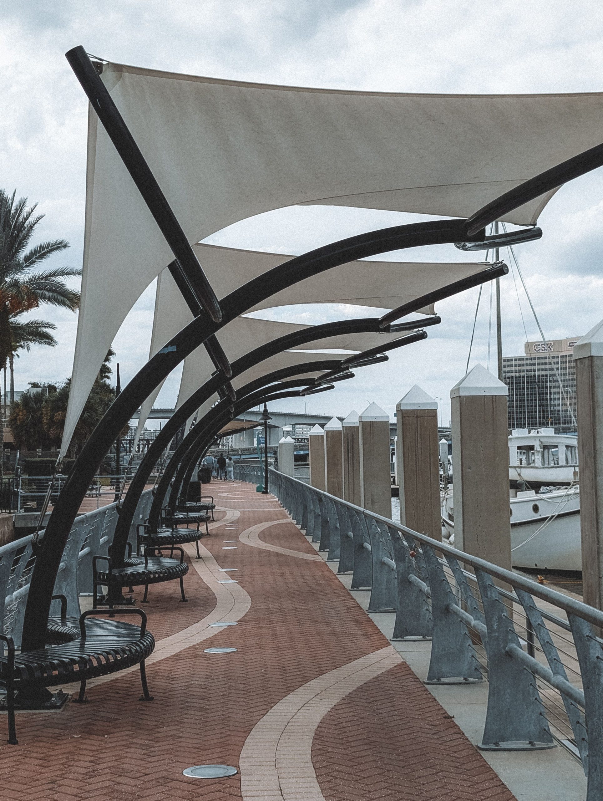A scenic marina promenade with stylish sail shades and seating in Jacksonville, Florida.