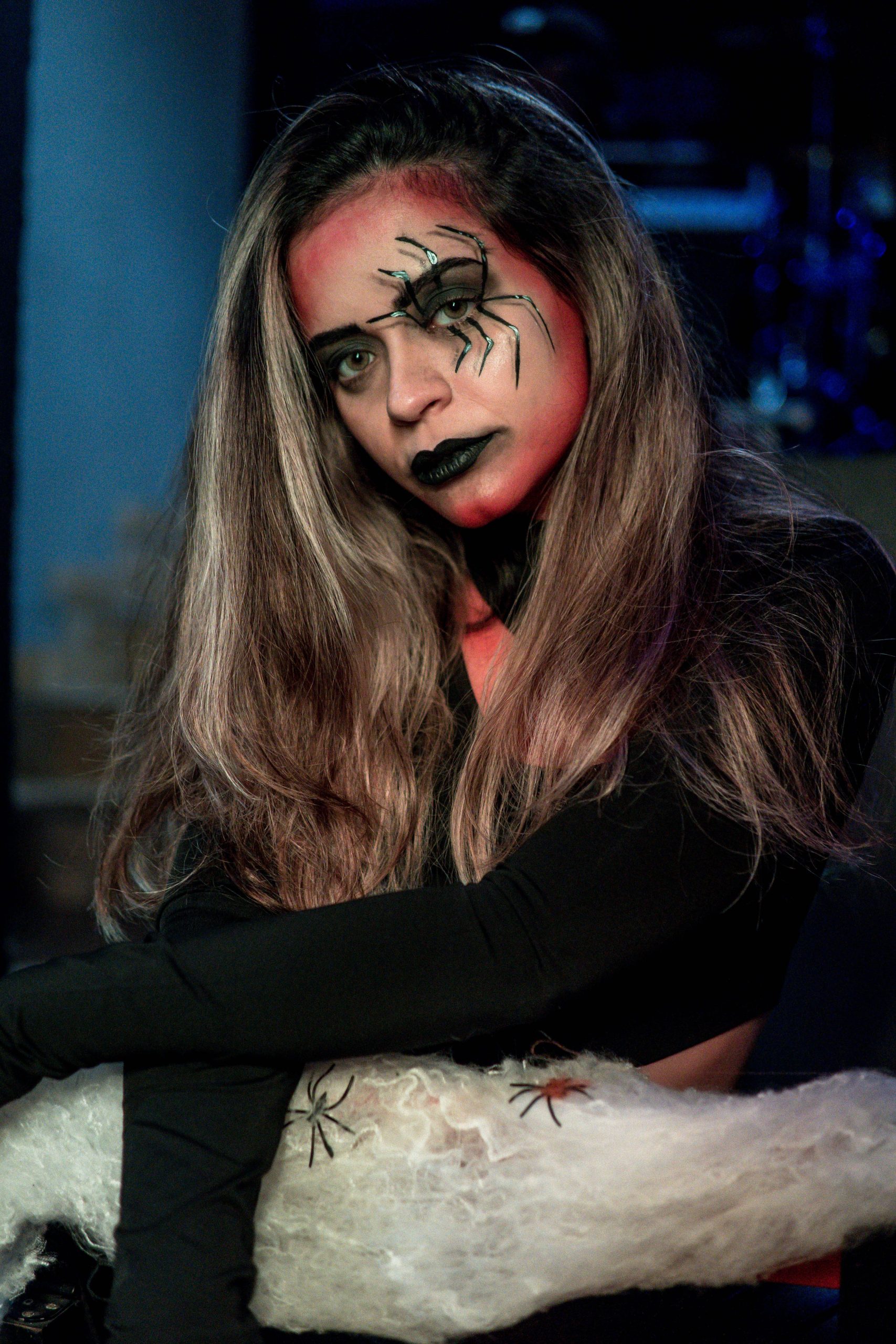 A woman dressed as a spider lady with gothic makeup for Halloween.
