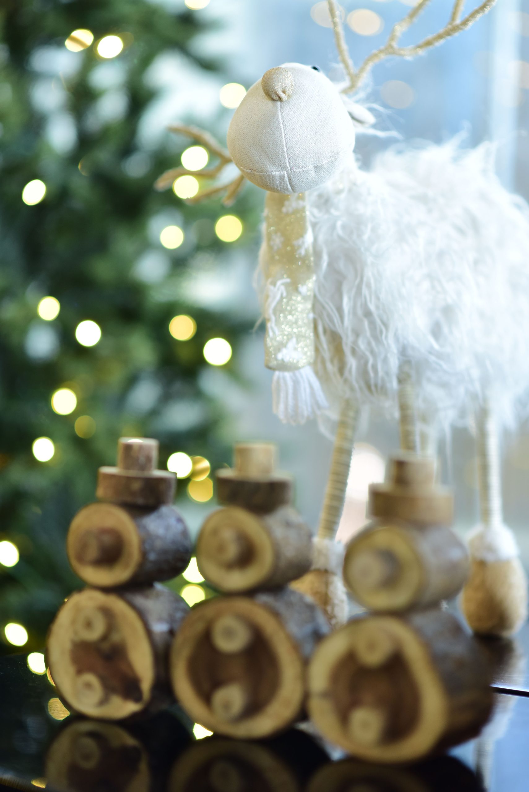 Adorable reindeer plush and wooden log decoration for Christmas.