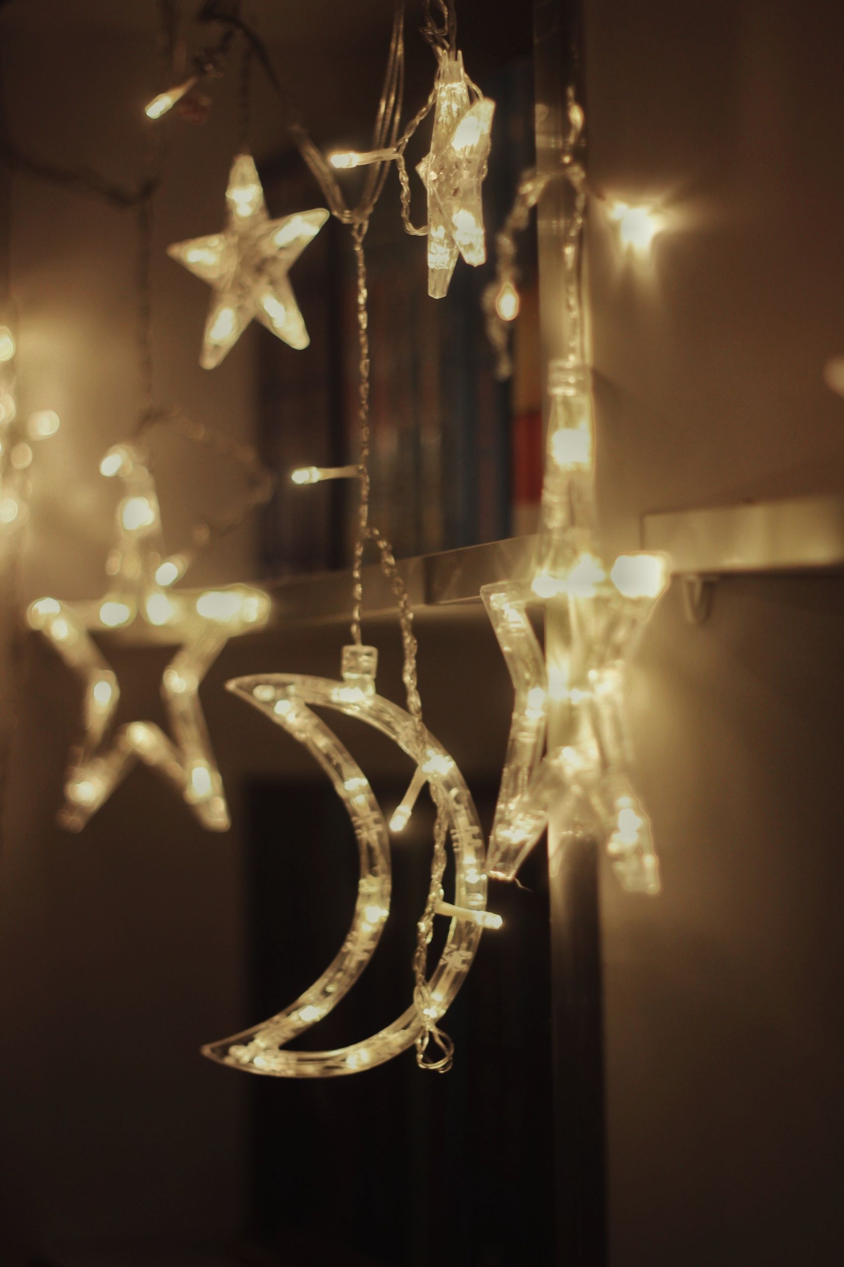 Ambient LED star and moon lights casting a warm glow indoors, perfect for cozy decorations.