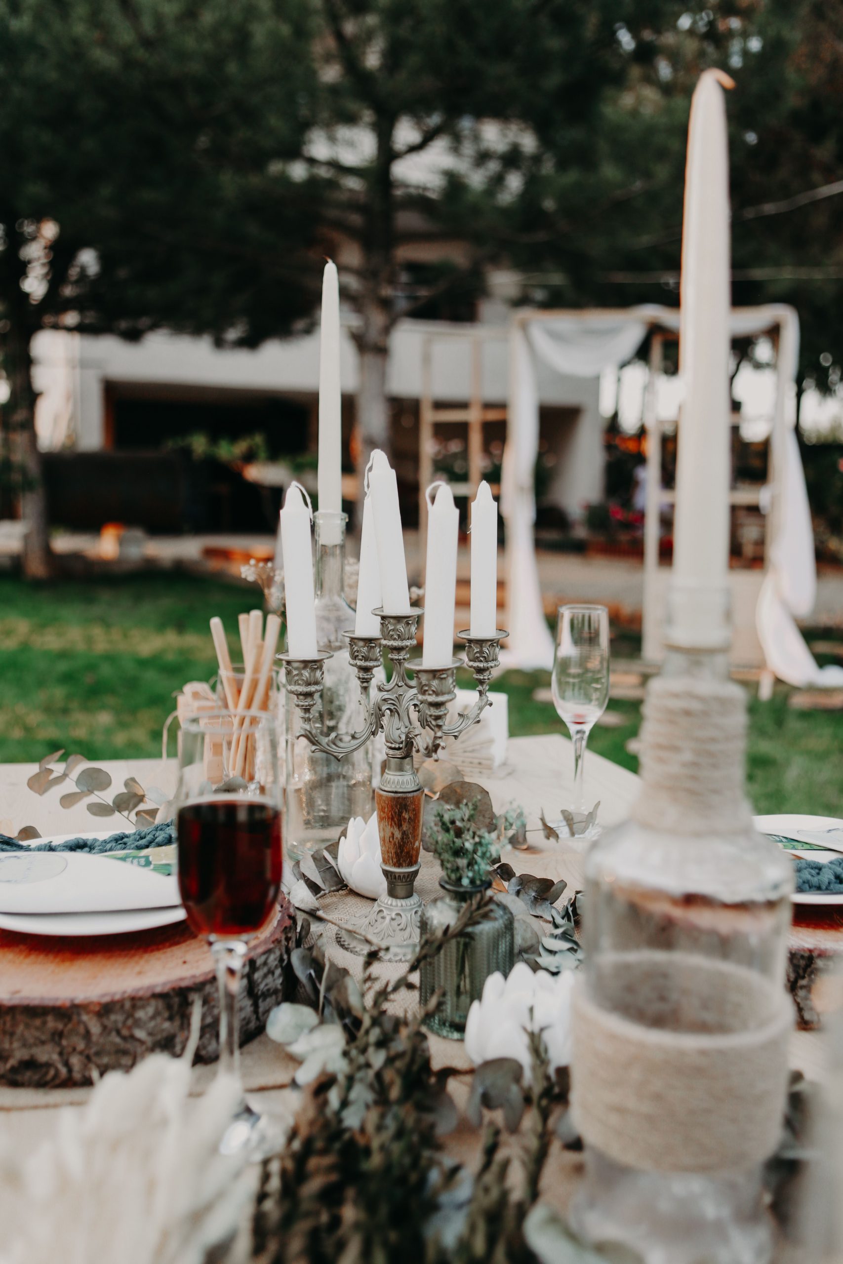 Charming outdoor dinner table setup with candles and rustic decor for a cozy ambiance.
