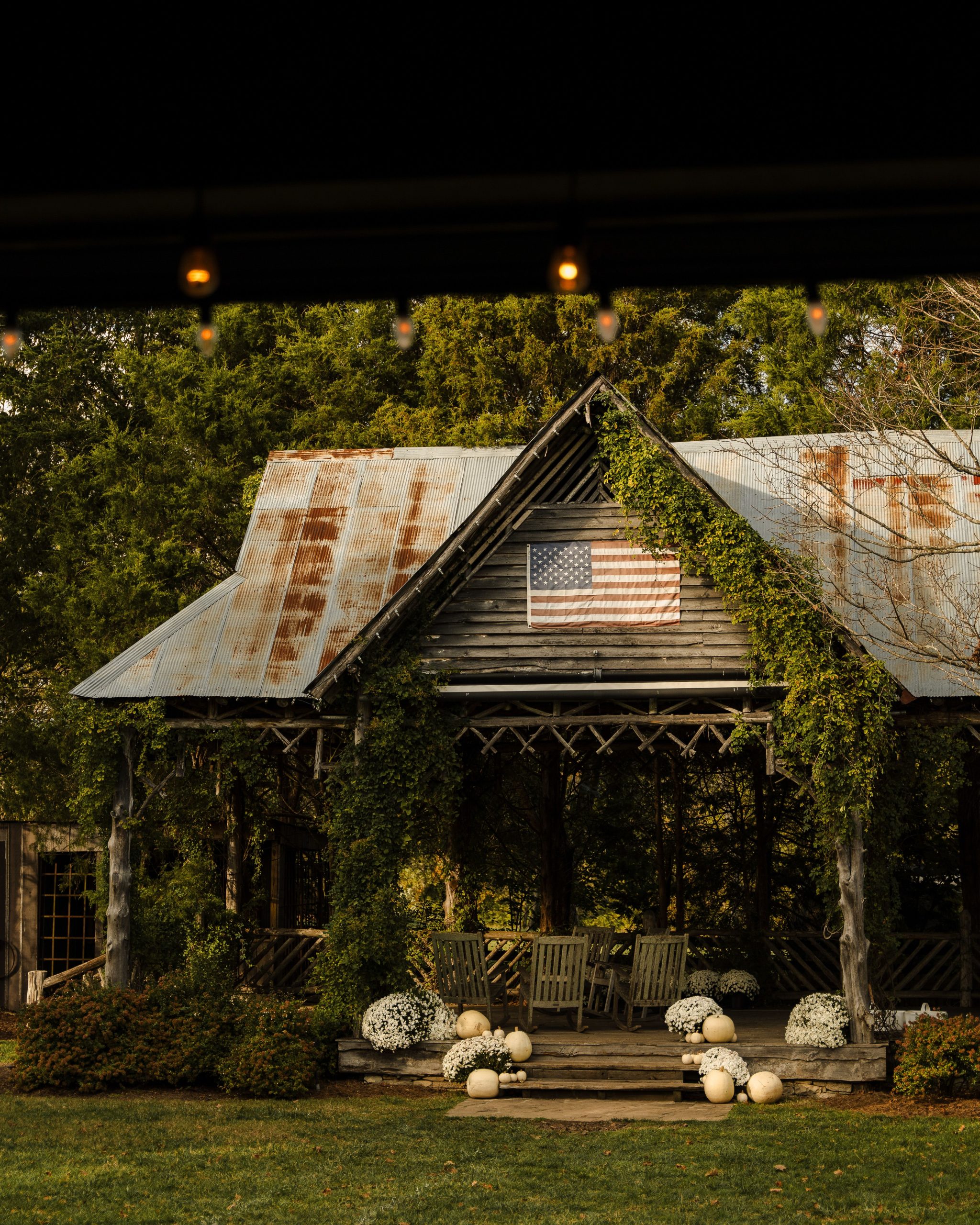 Charming rustic barn adorned with fall pumpkins and a US flag, perfect for autumn themes.