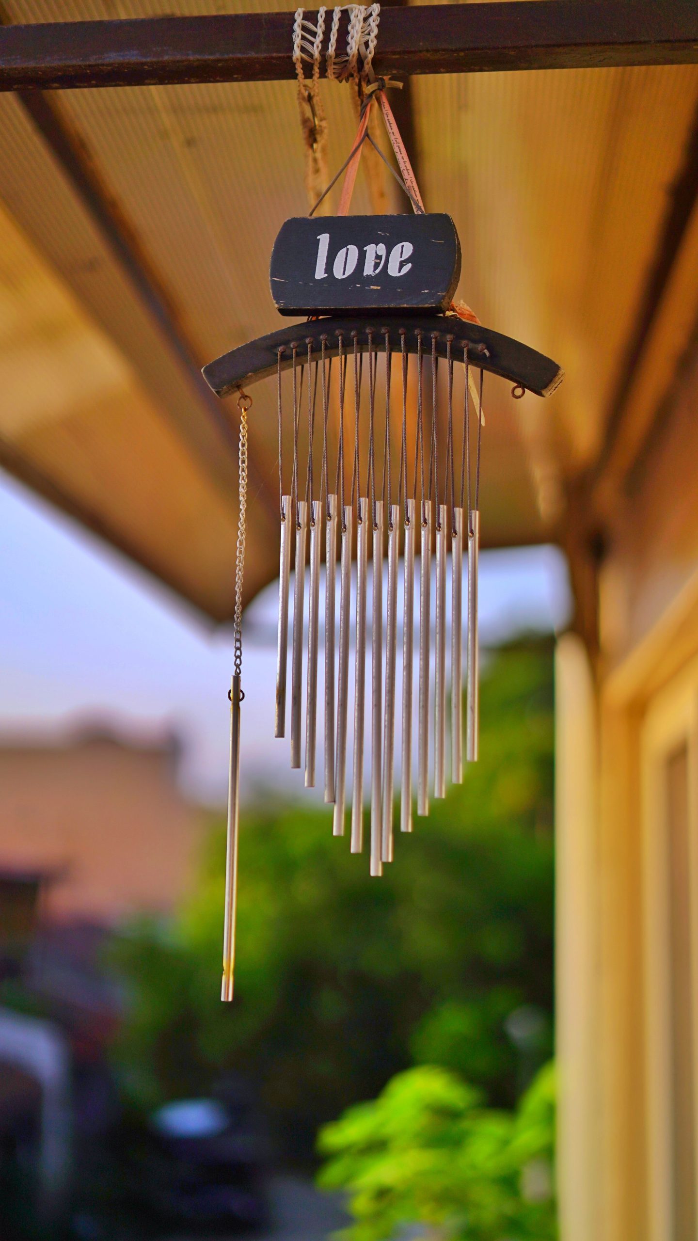Charming wind chime with love decoration hung outdoors capturing a serene atmosphere.