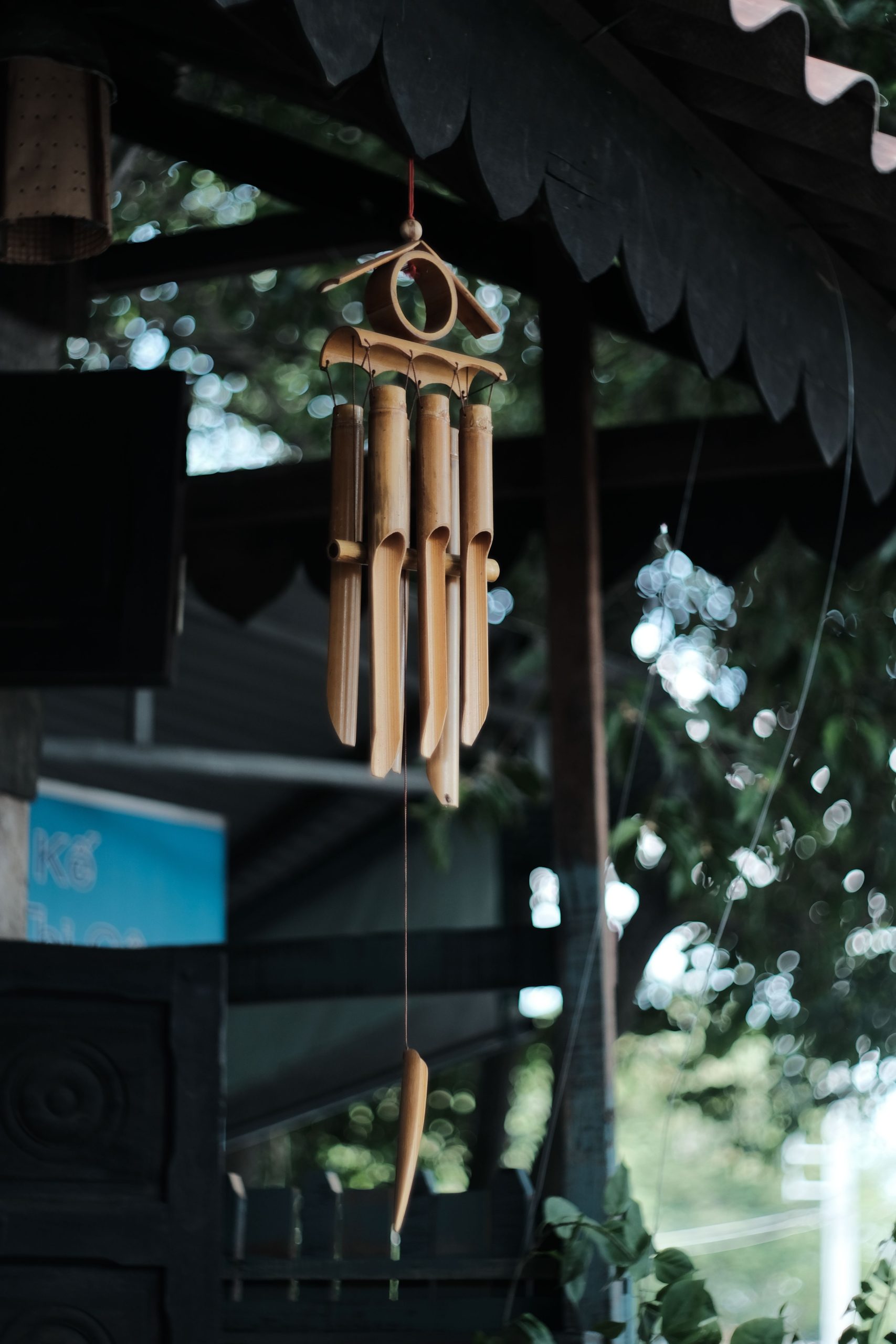 Close-up of bamboo wind chimes hanging outdoors with natural backdrop.