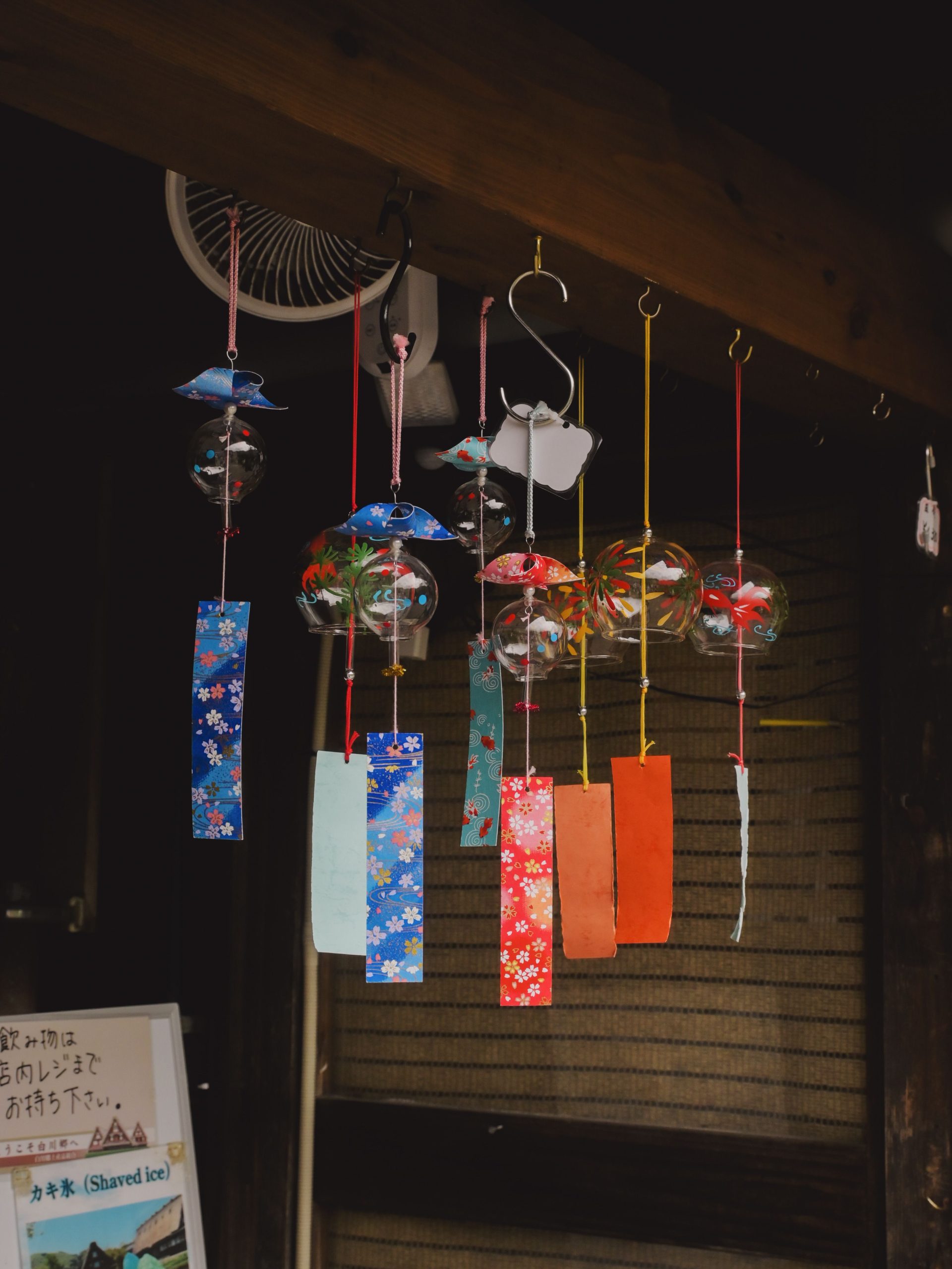 Colorful Japanese wind chimes hanging in a traditional setting, adding cultural charm.