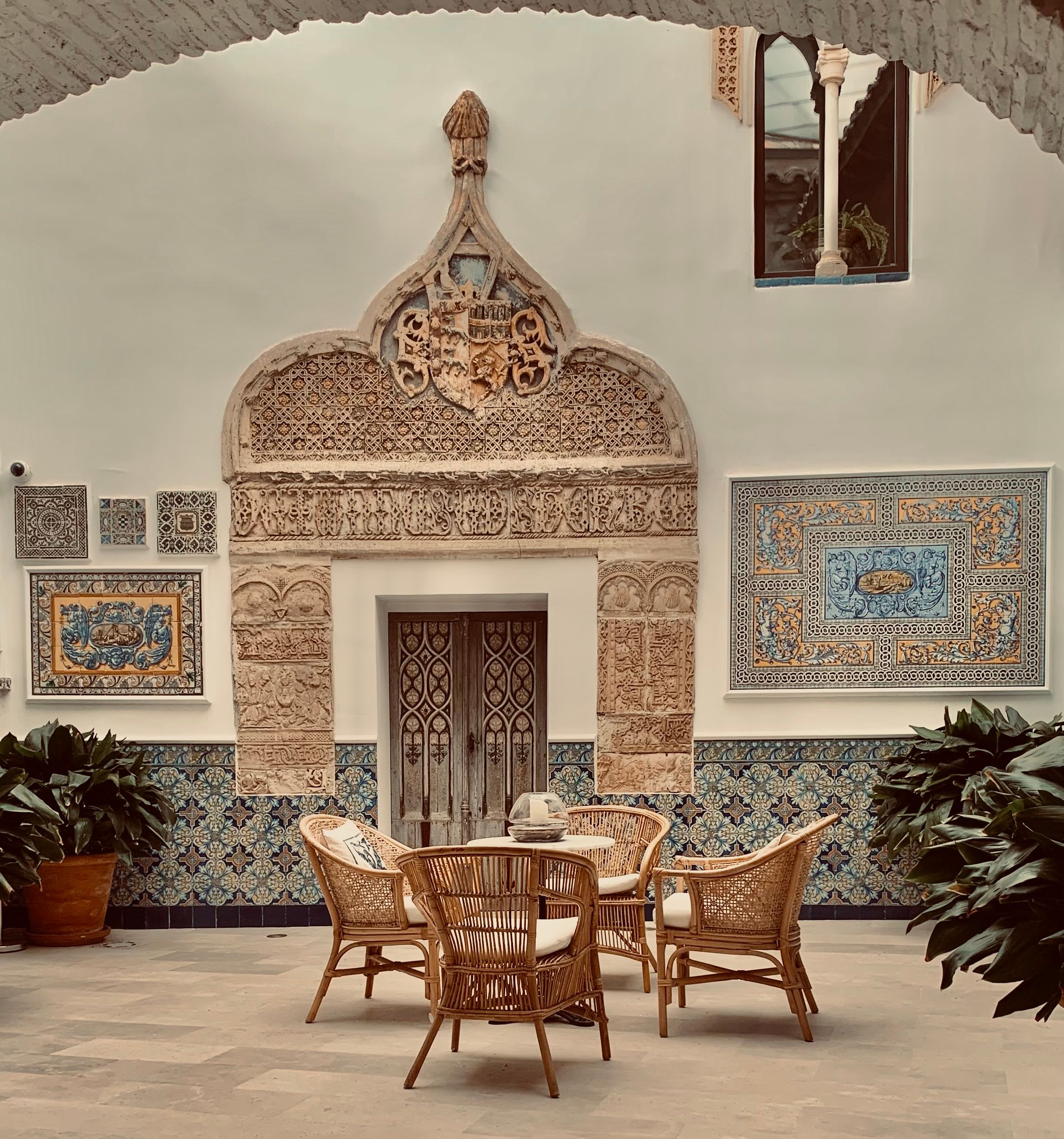Elegant Andalusian style courtyard with decorative tile work and wicker furniture in Oropesa, Spain.