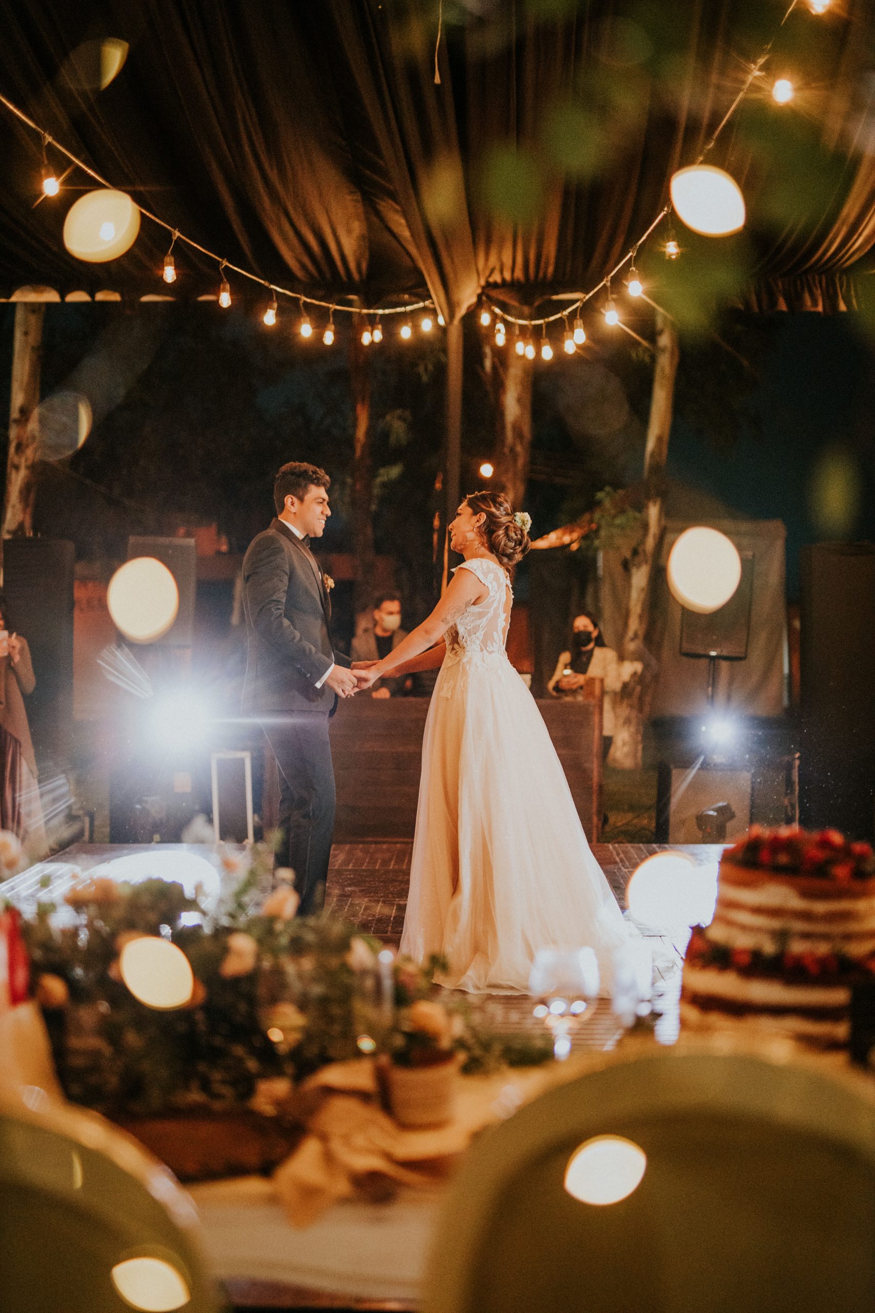 Elegant evening wedding with string lights and a beautiful dance setting.