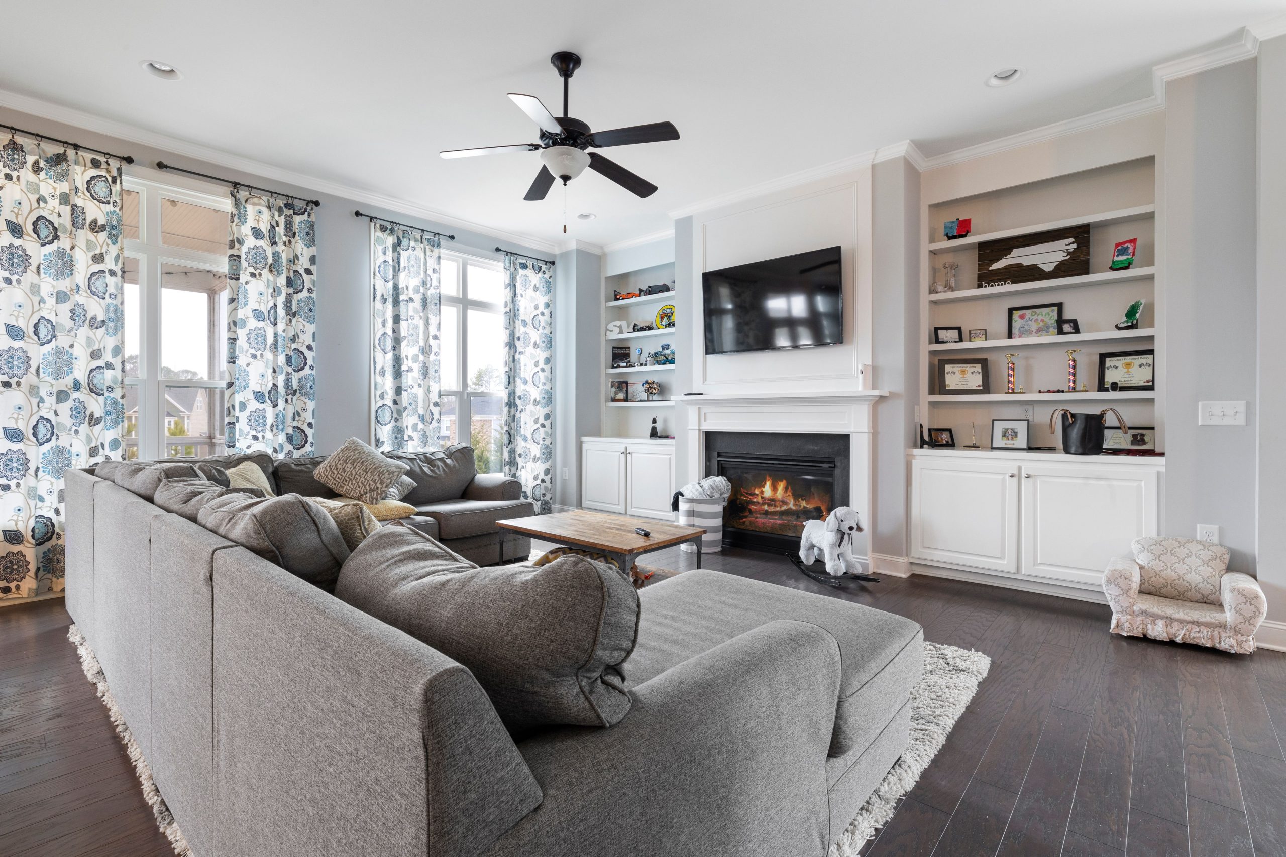 Elegant living room featuring a cozy corner sectional sofa and warm fireplace.