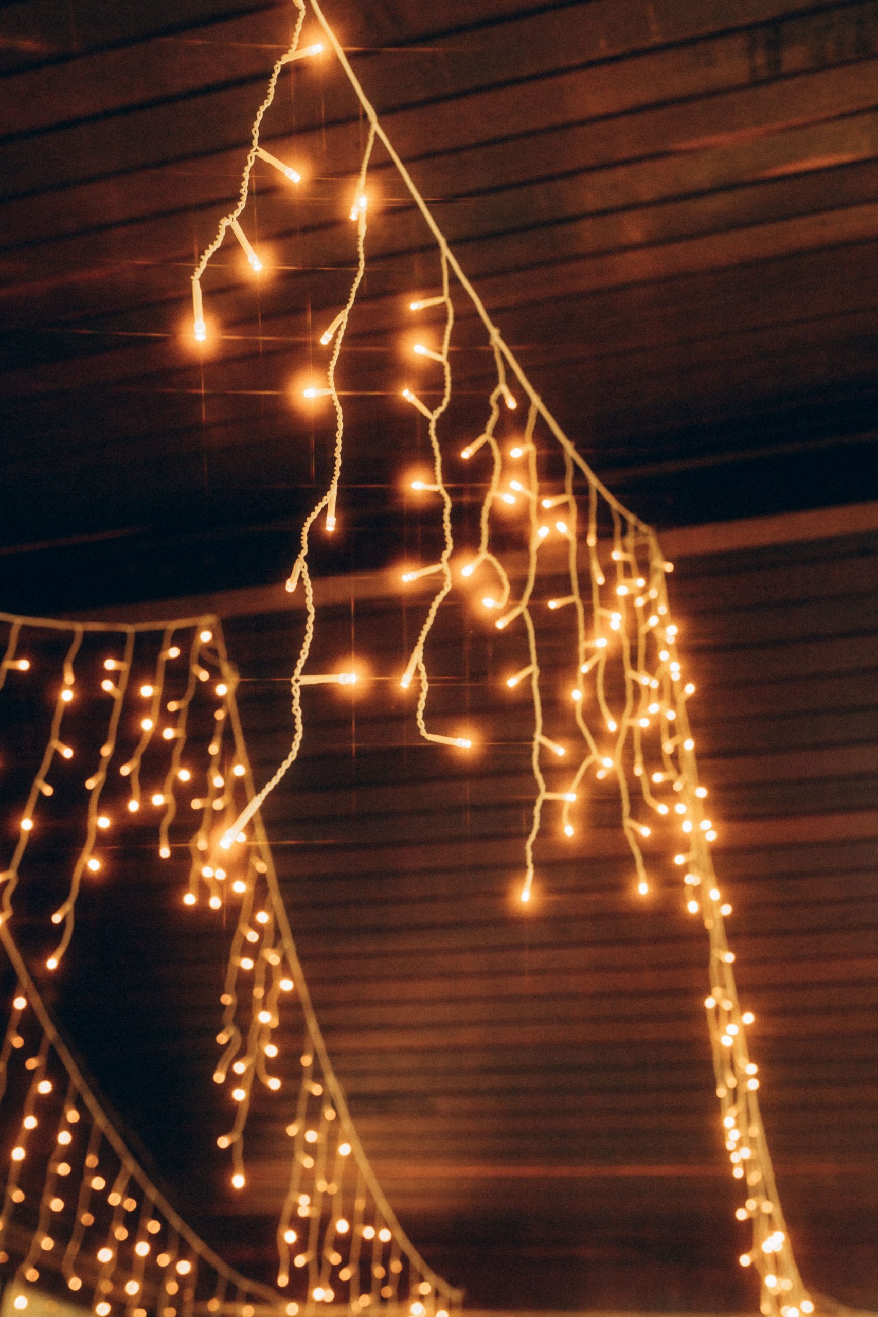 Golden fairy lights cascade elegantly inside a cozy indoor setting, creating a warm and festive ambiance.